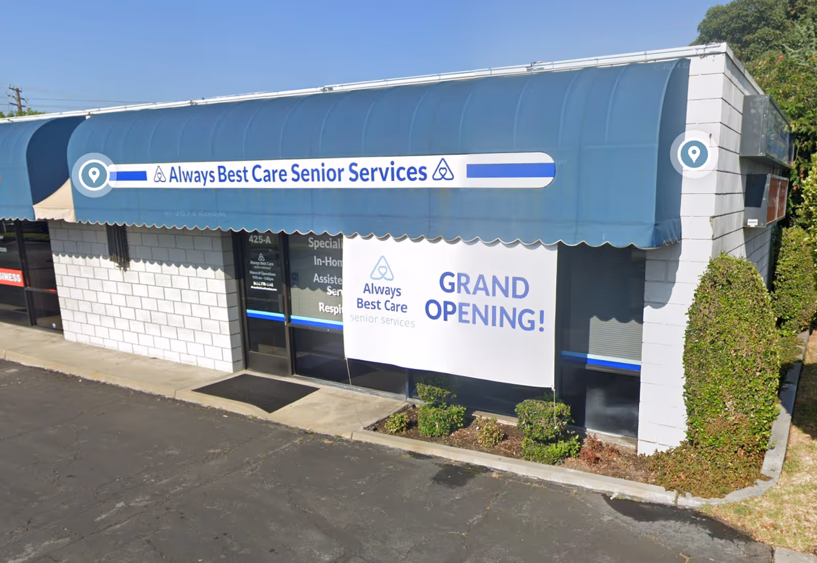 Blue awning storefront with Always Best Care sign and grand opening banner