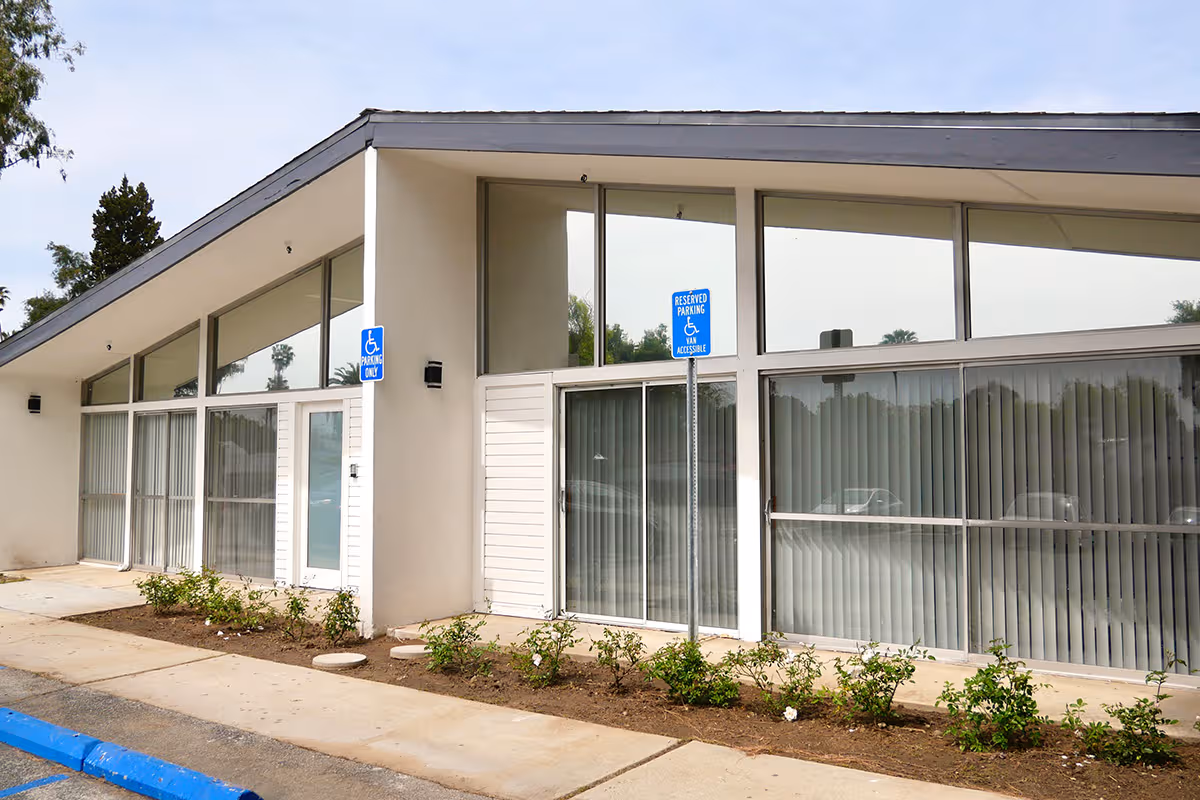 Pasadena Villa Assisted Living exterior: modern glass-fronted building with landscaped frontage