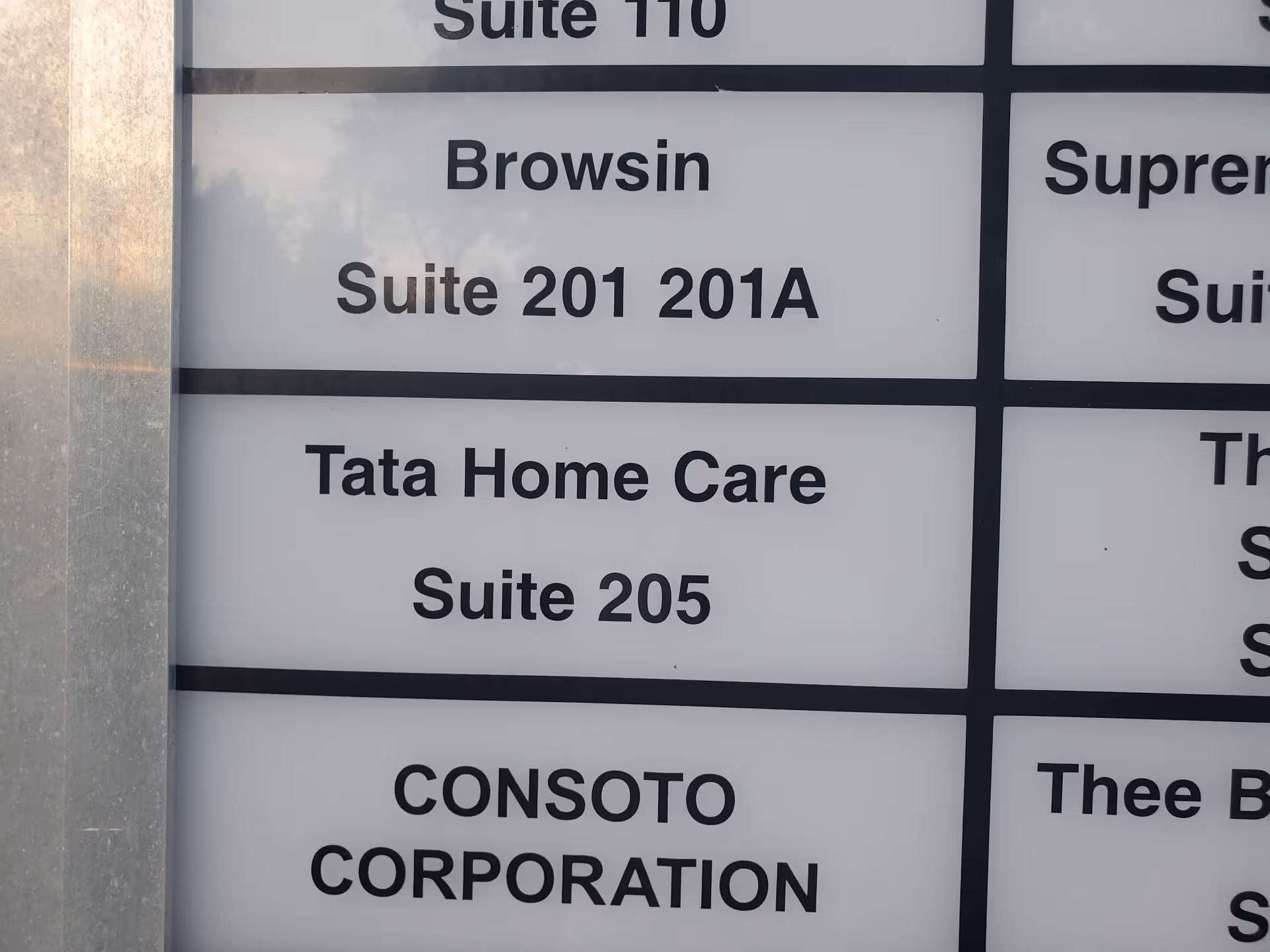 Exterior building directory sign showing Tata Home Care Suite 205