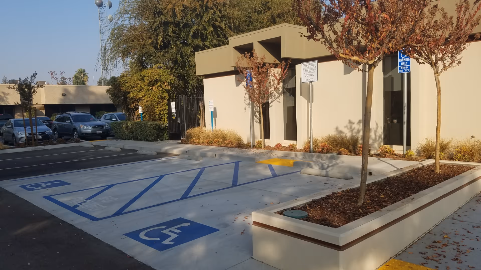 Exterior view of a beige facility with handicapped parking and landscaped planters