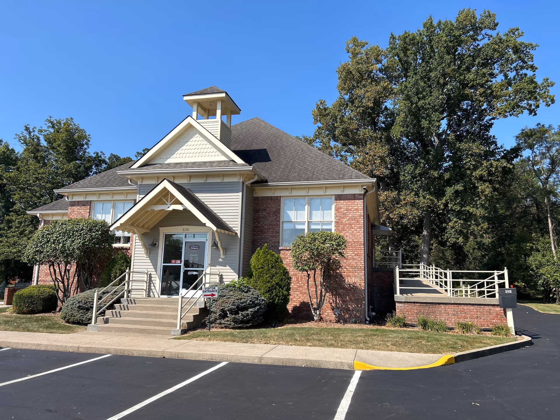 Exterior view of a senior care facility with brick siding and front entrance.
