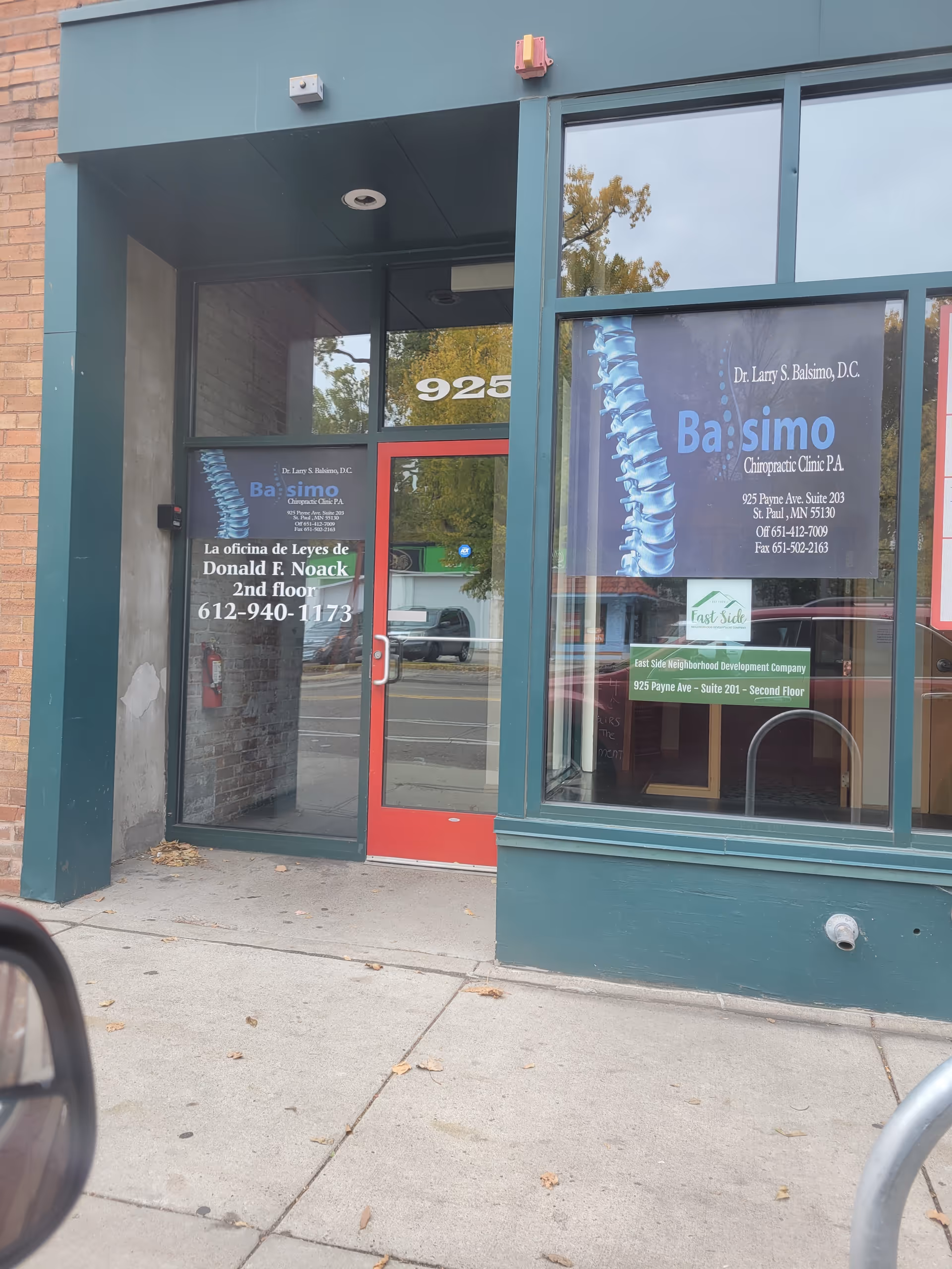 Exterior storefront with glass door and chiropractic clinic signage in windows