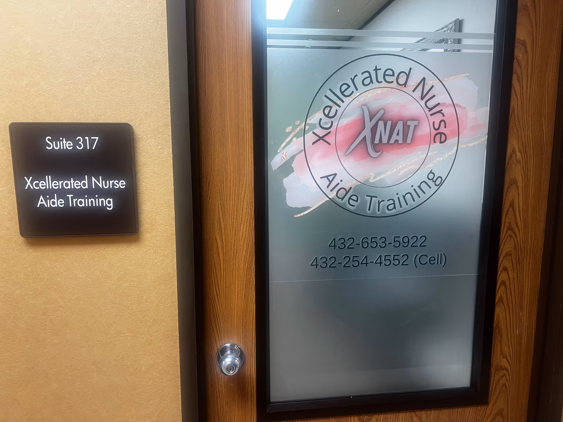 Interior doorway featuring Xcellerated Nurse Aide Training logo and Suite 317 sign.