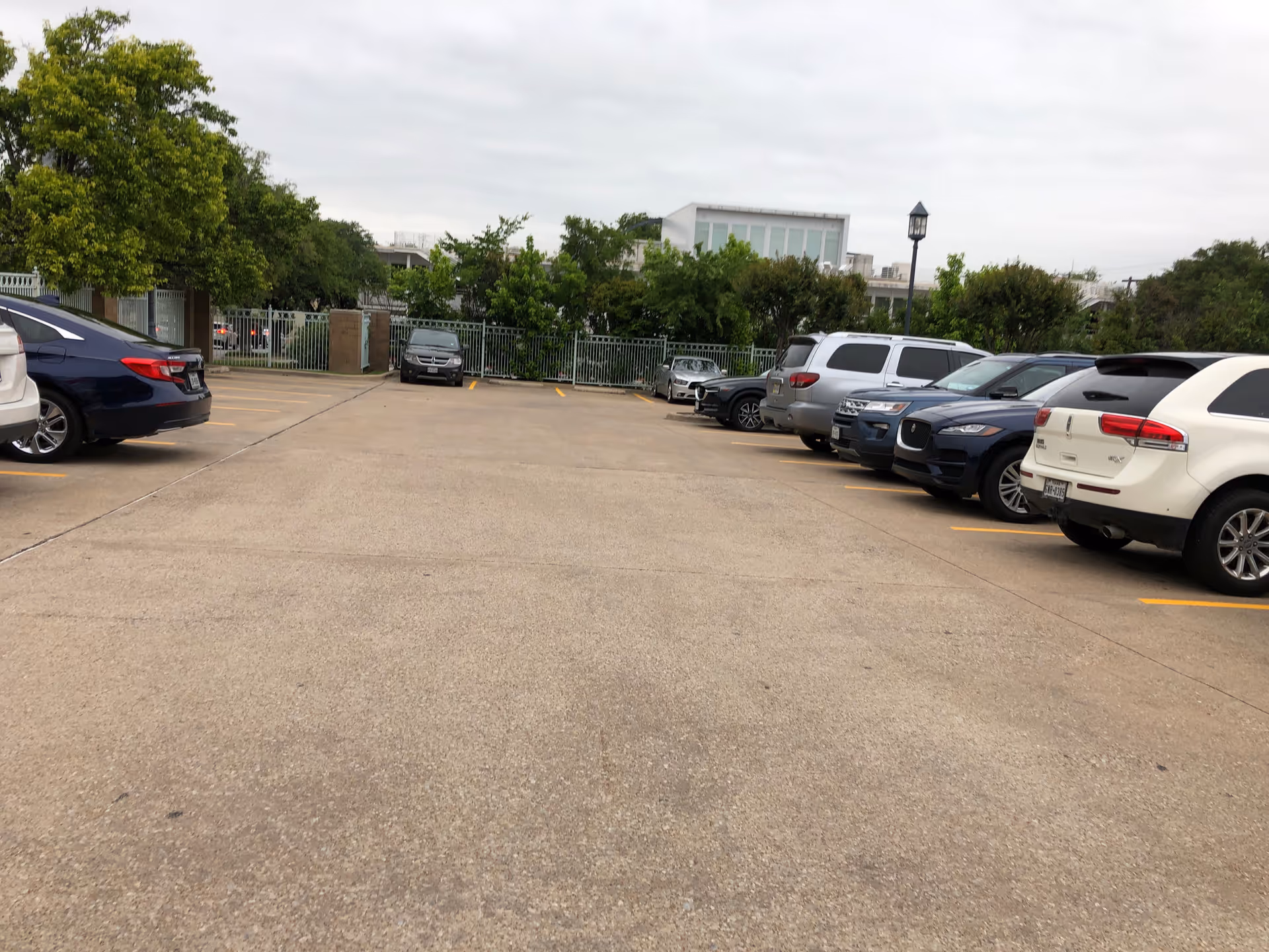 Parking lot in front of a senior center with parked cars and trees.