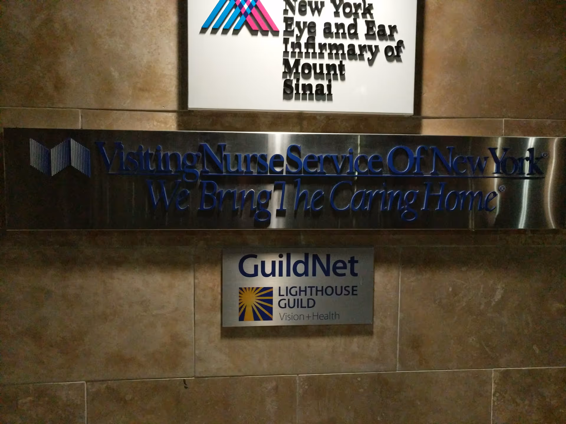 Interior wall with blue Visiting Nurse Service of New York sign and GuildNet plaque.