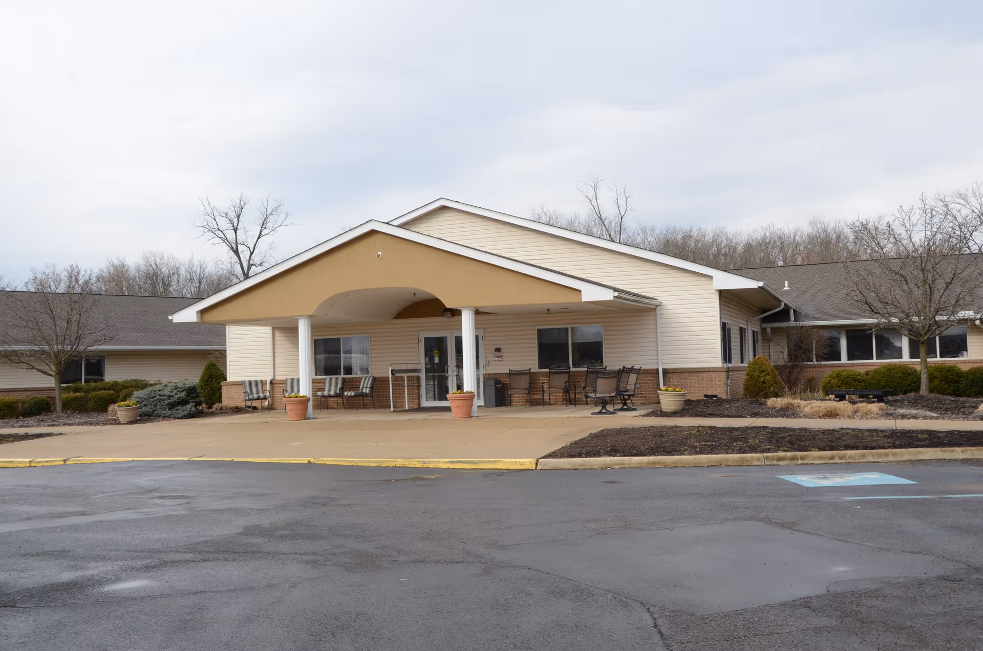 Exterior view of Englewood Health and Rehab entrance with seating under a covered front porch.