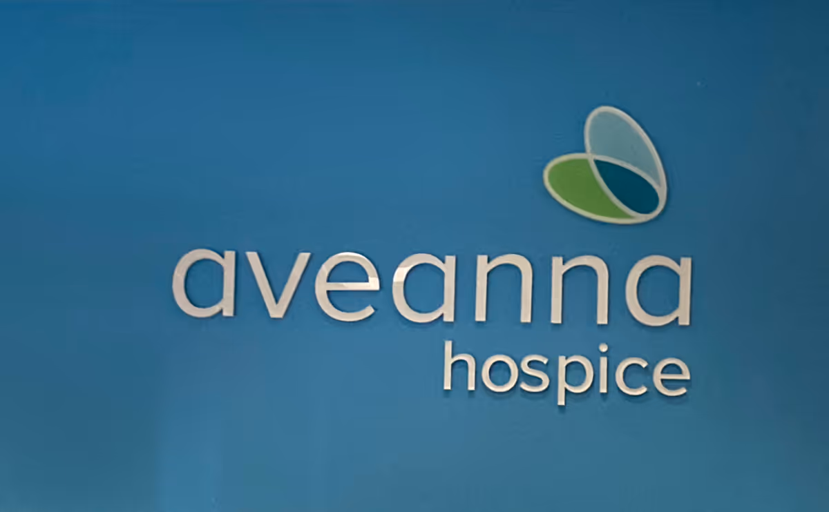 Blue wall displays Aveanna Hospice logo and name in white lettering.