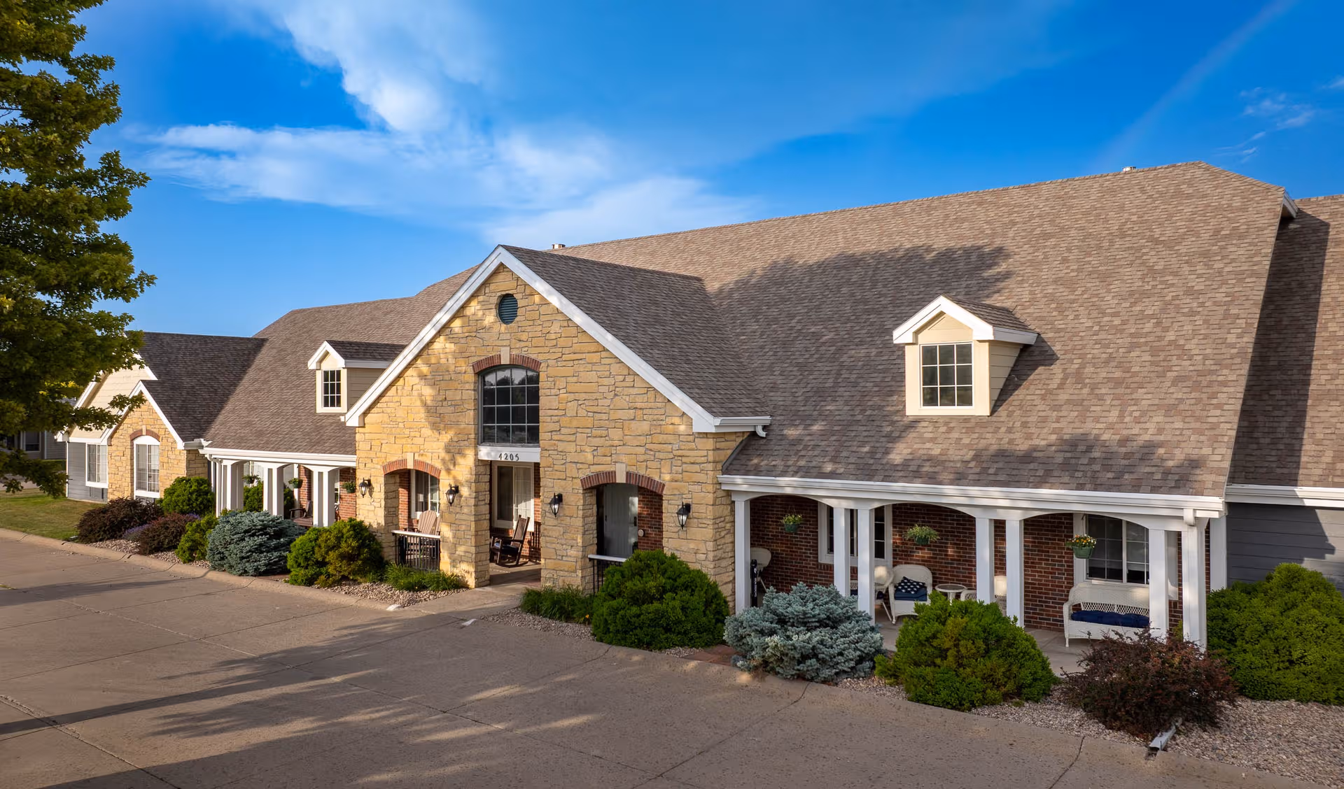 Exterior view of Homestead Assisted Living of Kearney with stone facade and porch.