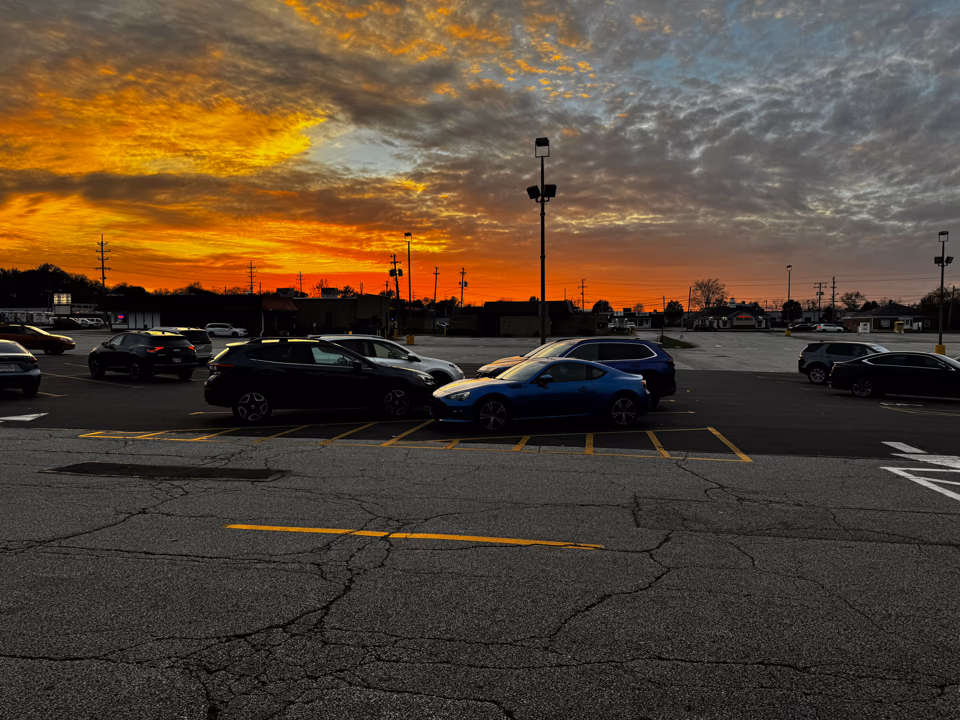 Sunset over Himalayan Healthcare Services parking lot with several cars.