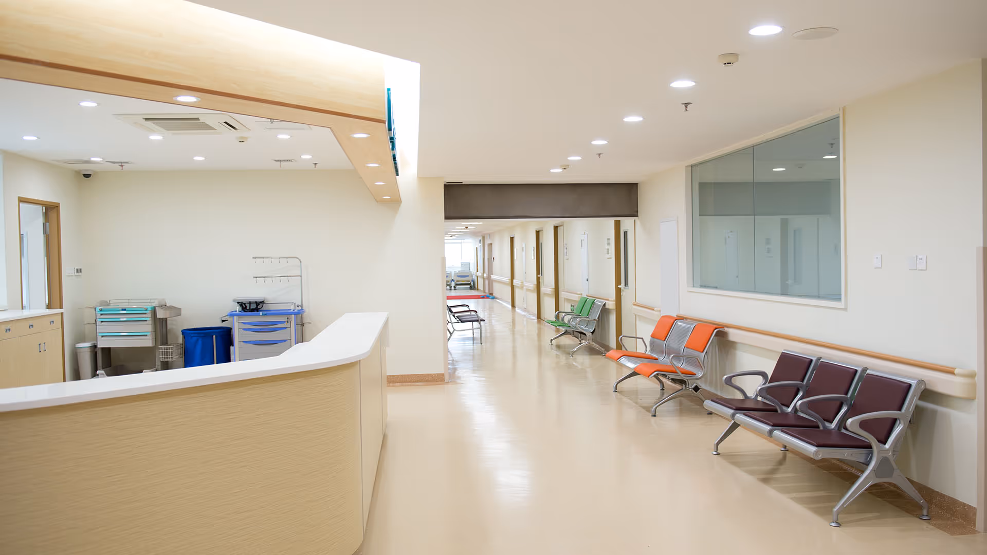 Bright reception area with a long hallway and colorful seating along the wall.