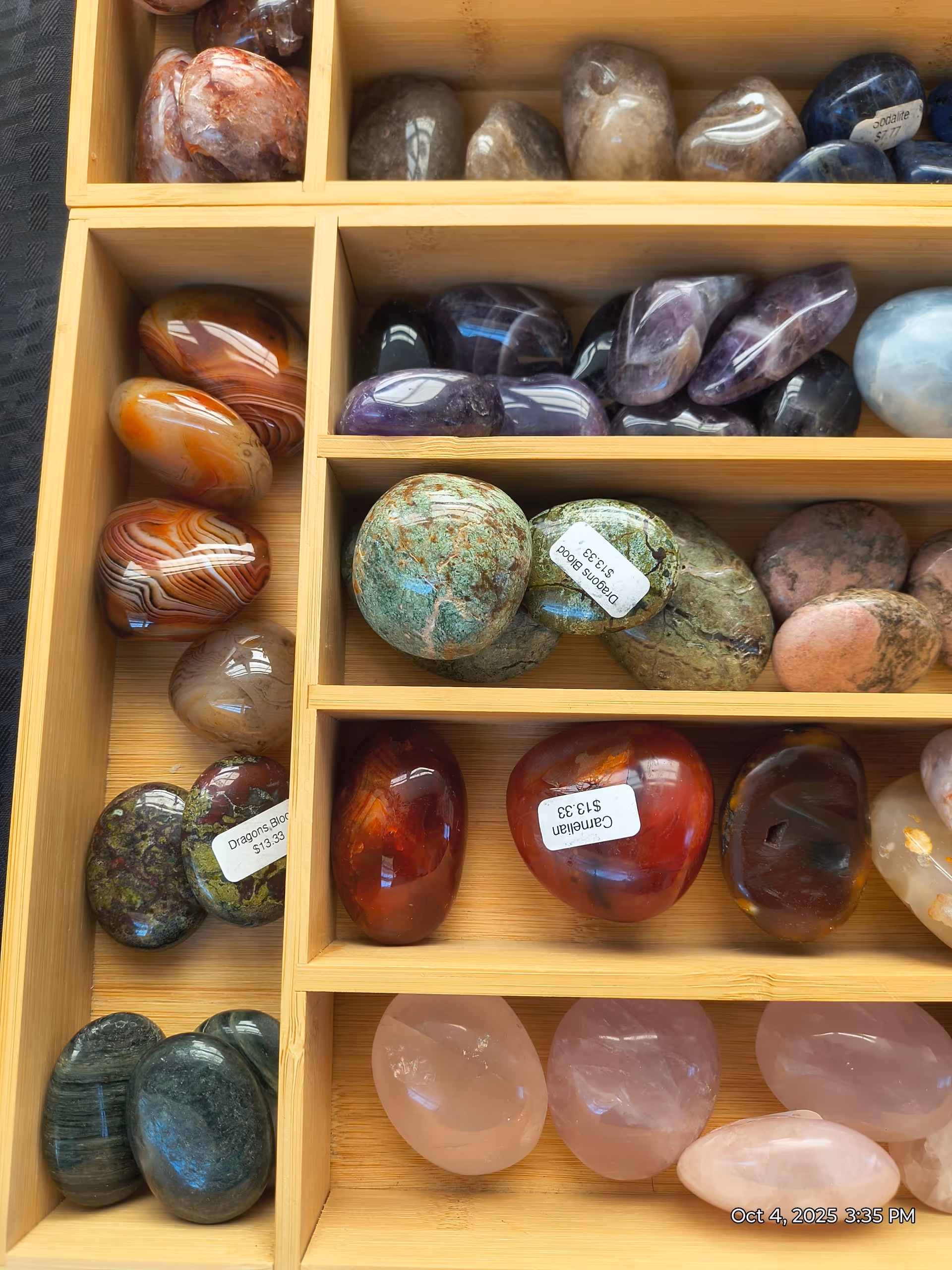 Wooden cubby shelves filled with colorful polished stones and crystals.