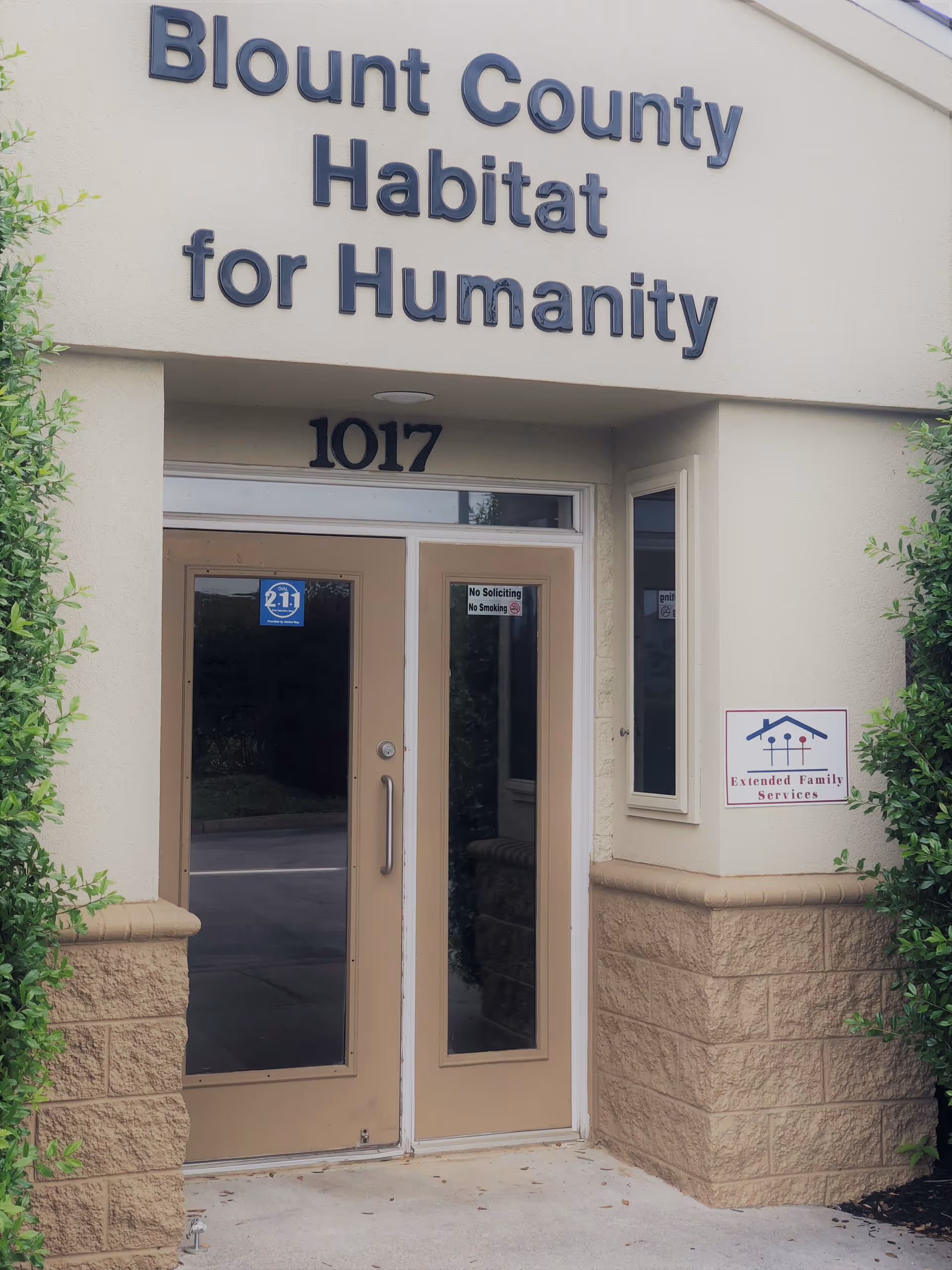 Entrance to Blount County Habitat for Humanity building with glass doors and Extended Family Services sign.