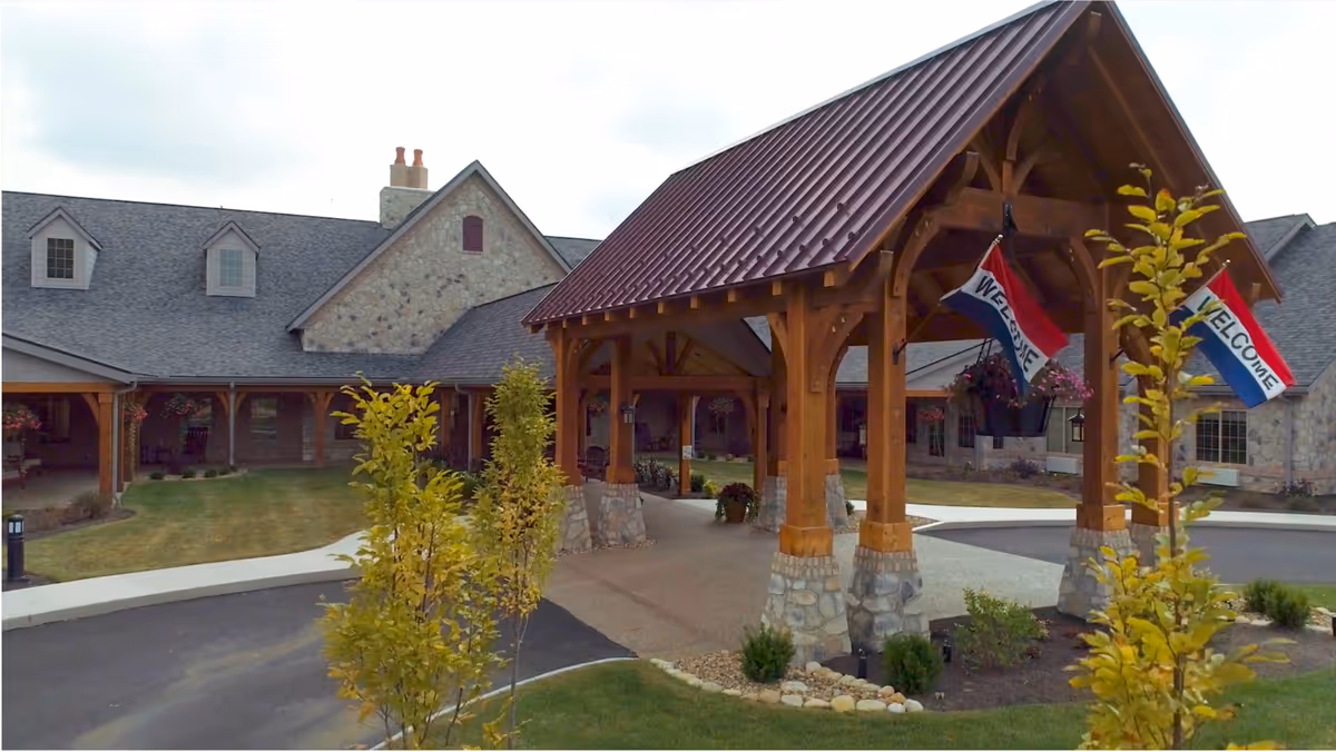 Inn At Summit Trail exterior with a wooden covered entrance and welcome flags.