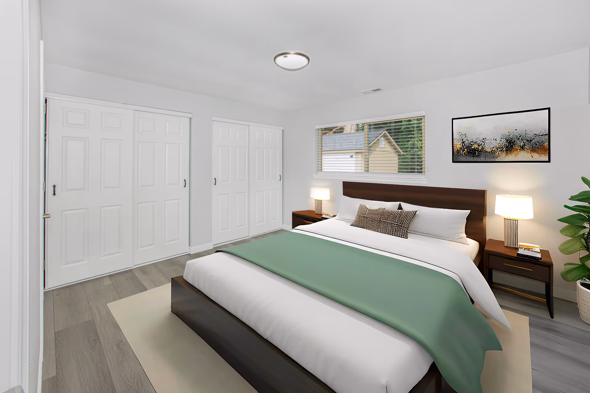 A clean, modern bedroom at Penny Creek Adult Family Home with a large bed and closets.