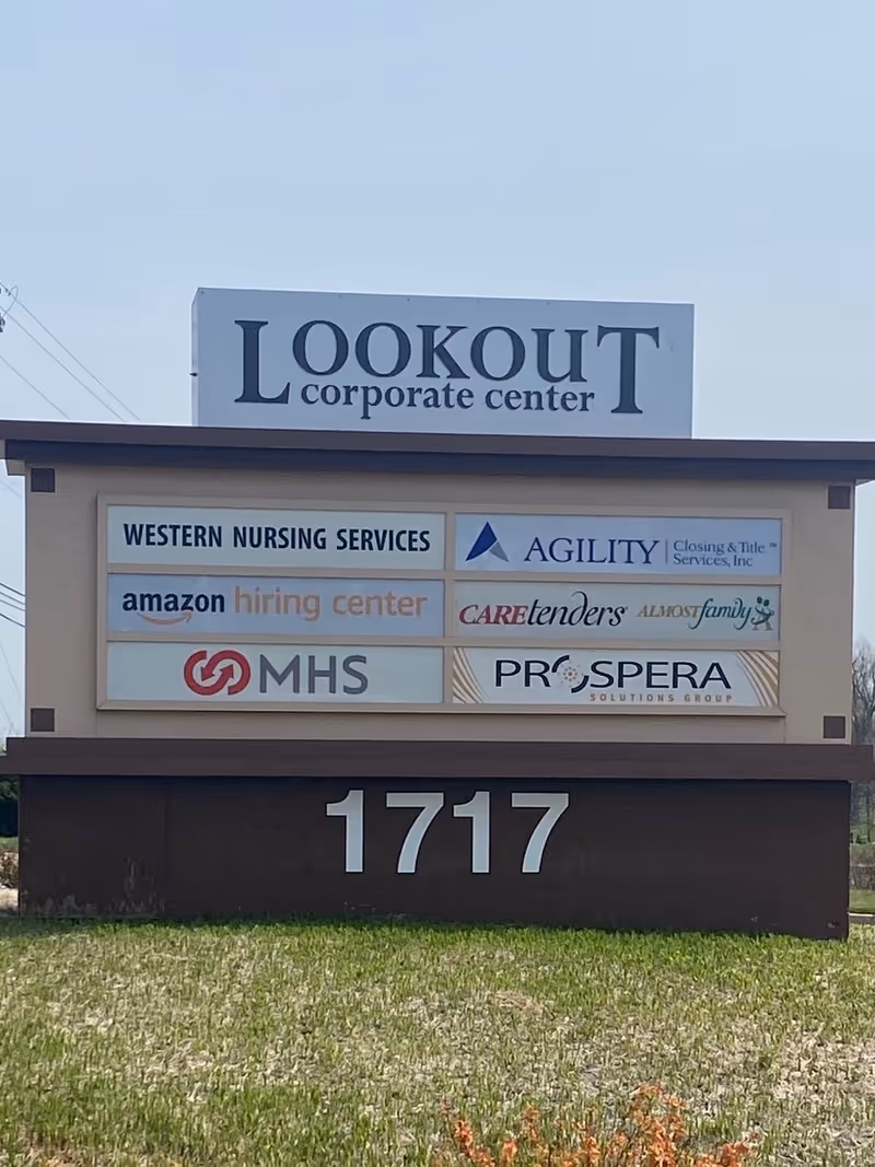 Outdoor signboard for Lookout Corporate Center with multiple tenant logos, including Caretenders.