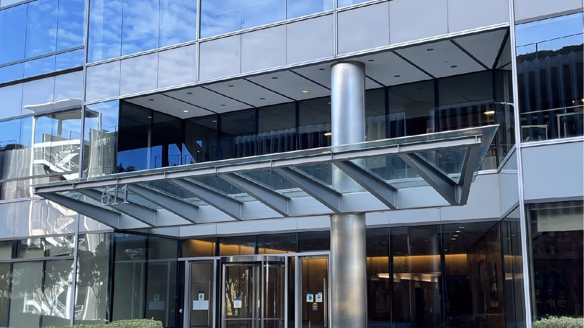 CareHealthNet exterior building entrance with glass facade, metal support column, and glass canopy.