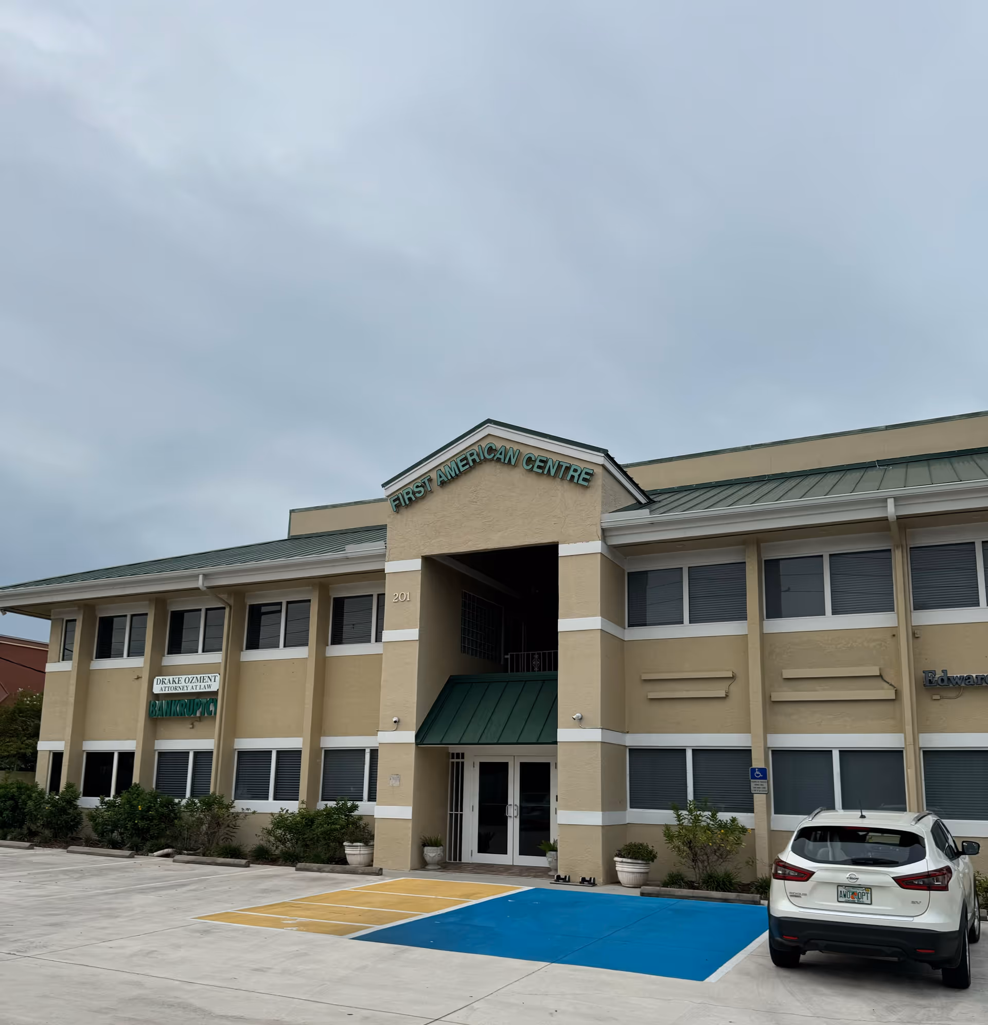 Exterior view of a senior care building with blue parking space and a car in front.