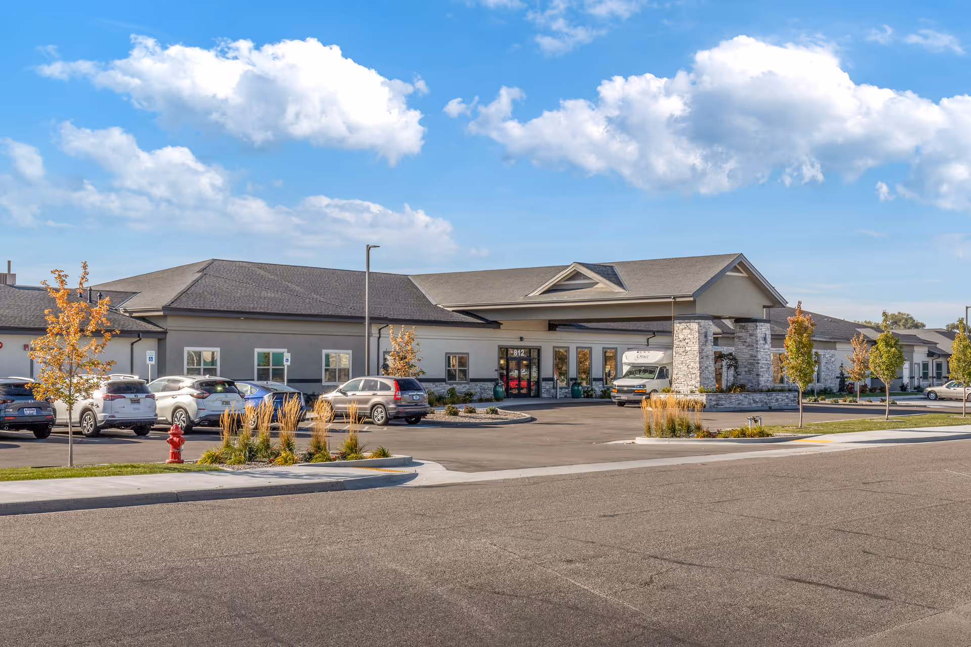 Exterior view of Grace Assisted Living - Fruitland with parked cars and entrance.