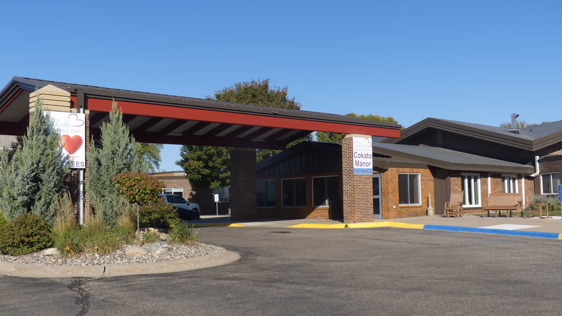 Exterior view of Cokato Manor entrance with driveway and brick façade.
