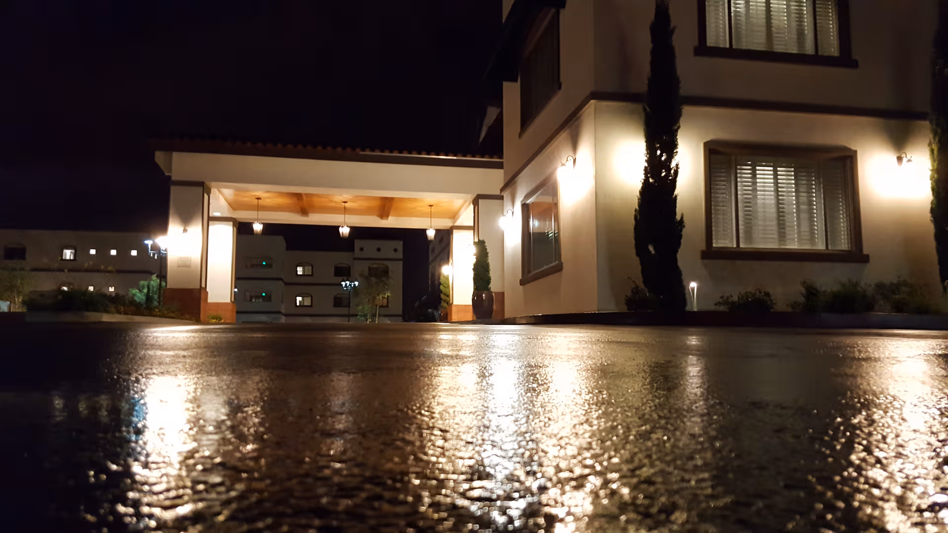 Night exterior of Clearwater at South Bay facility with an illuminated entrance and wet pavement.