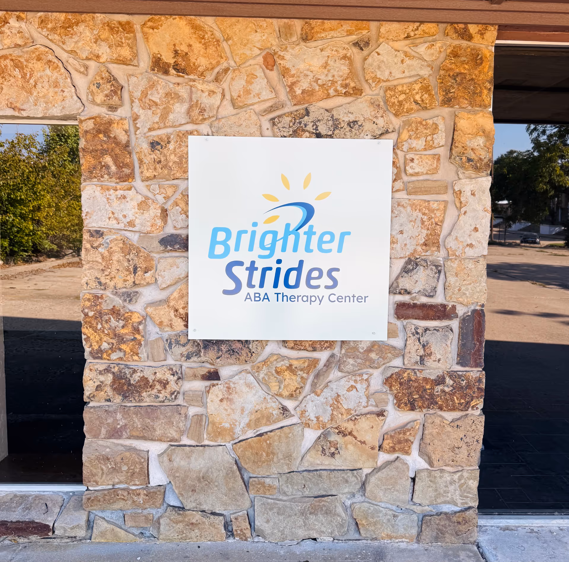 Stone facade with a Brighter Strides ABA Therapy Center sign mounted.