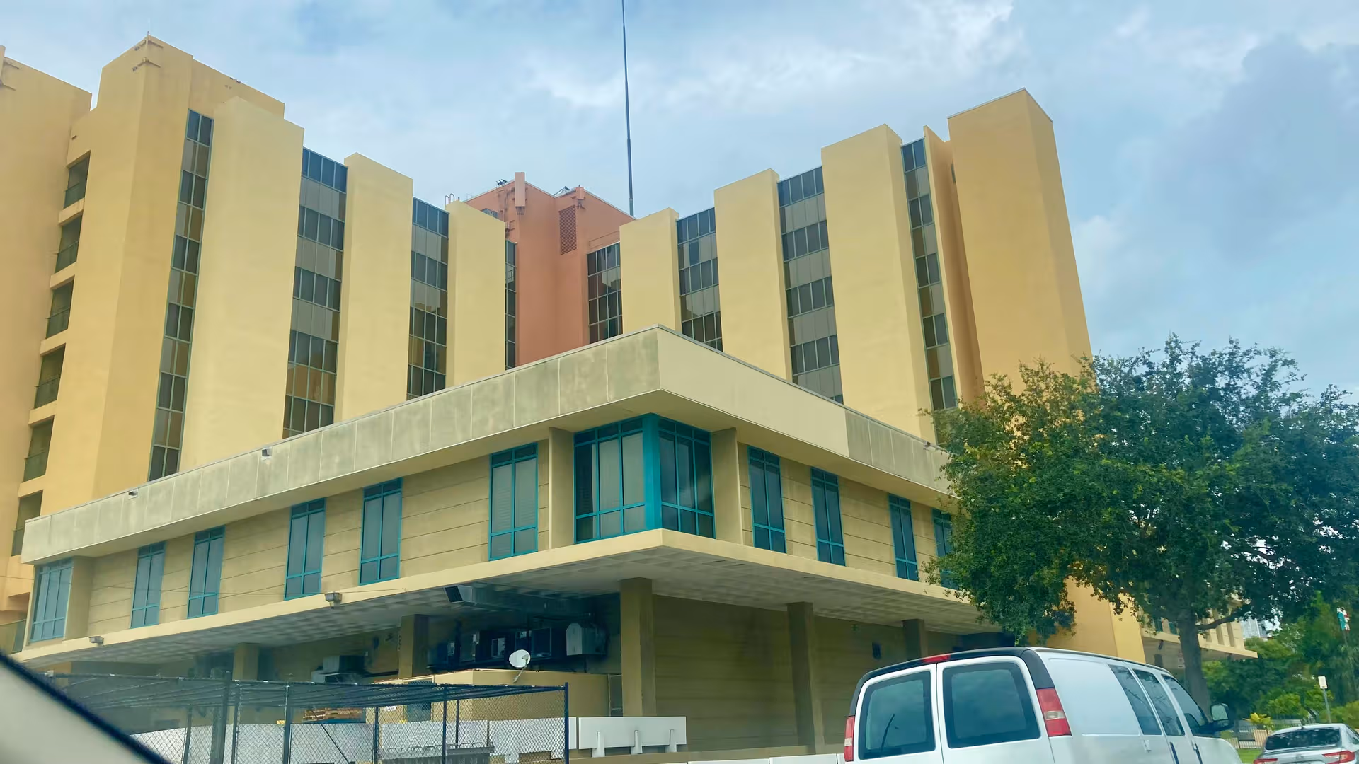 Exterior view of Victoria Nursing and Rehabilitation Center, a multi-story yellow facility with a drop-off area.