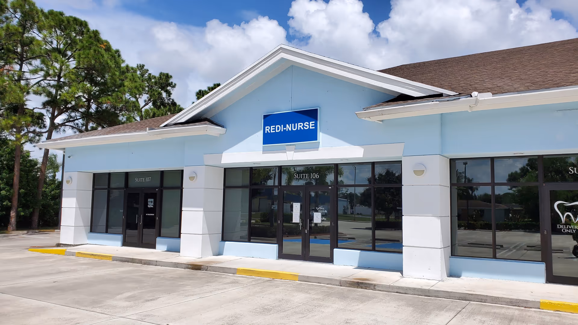 Light-blue, single-story senior living facility exterior with a blue REDI-NURSE sign.