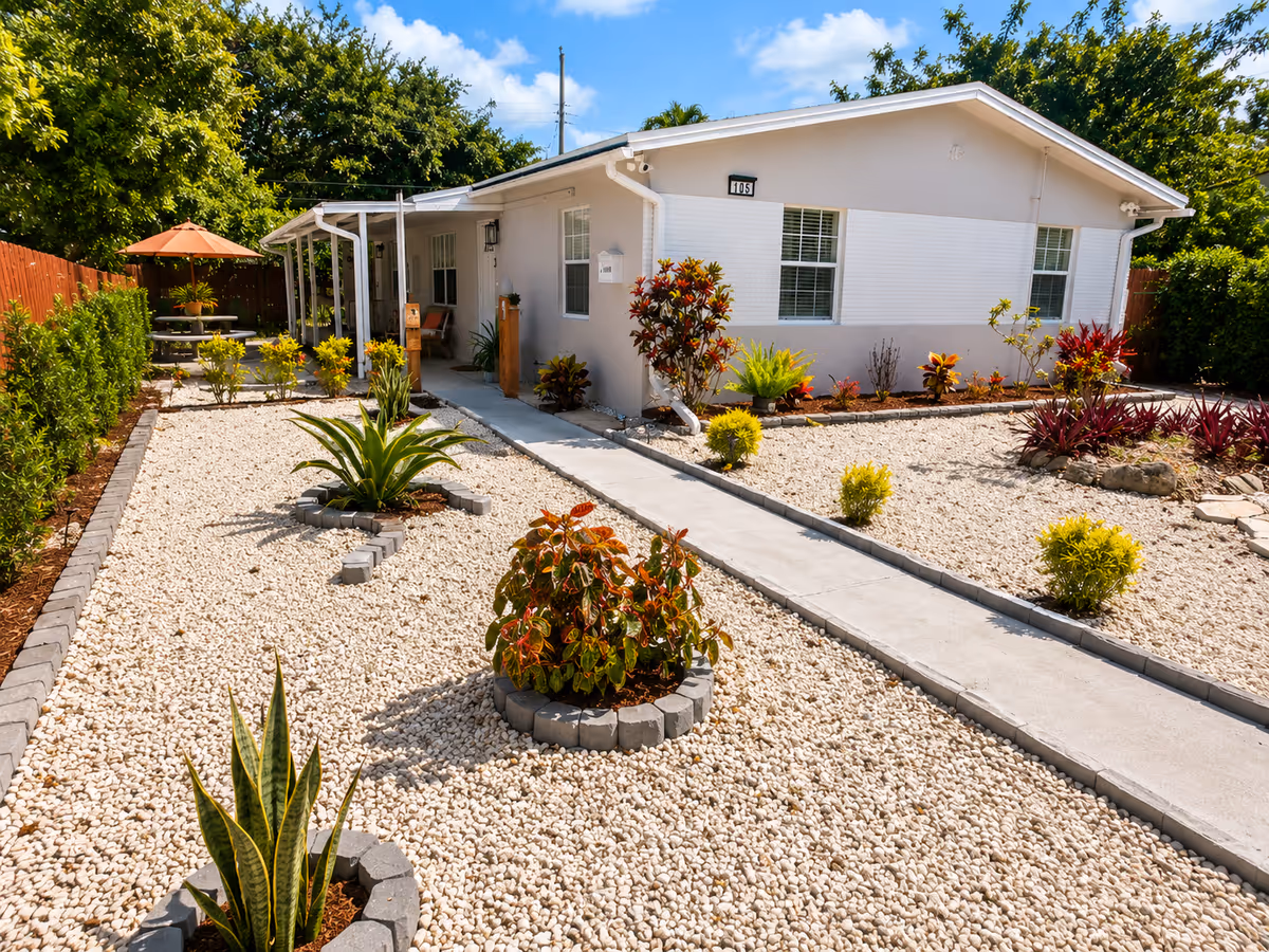 White single-story facility with gravel xeriscape, walkway, and seating area.