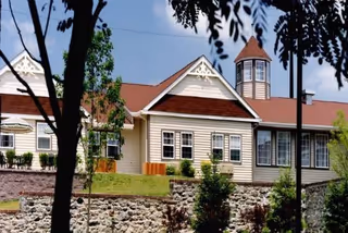 Exterior view of Truewood by Merrill, Glen Riddle, showing a beige building with a stone base.