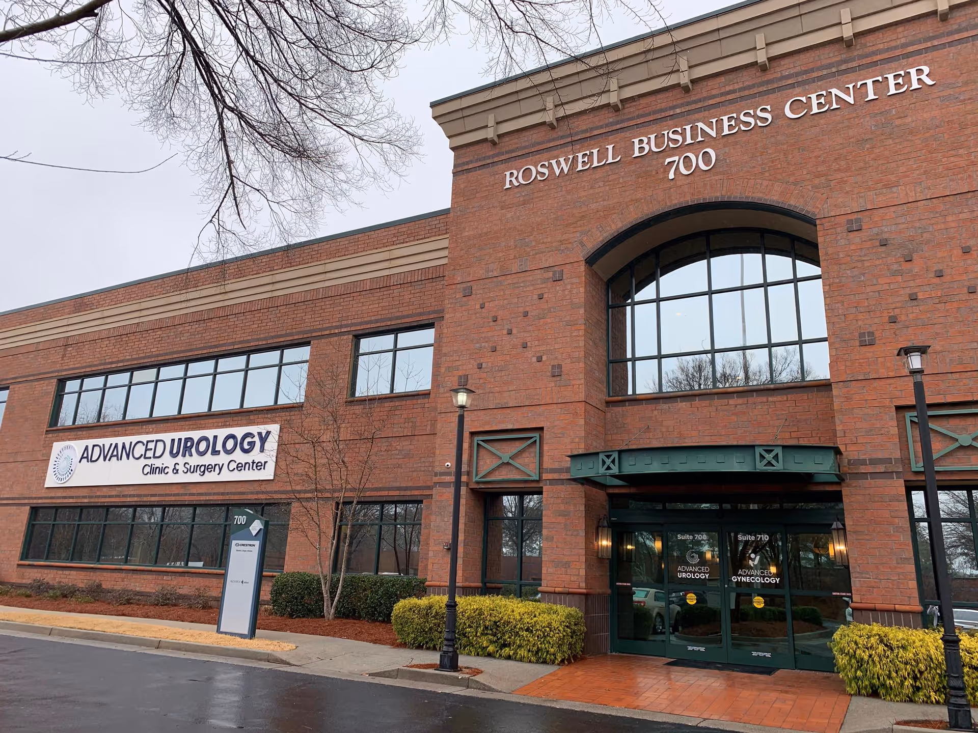 Brick medical clinic building with arched entrance and Roswell Business Center signage.