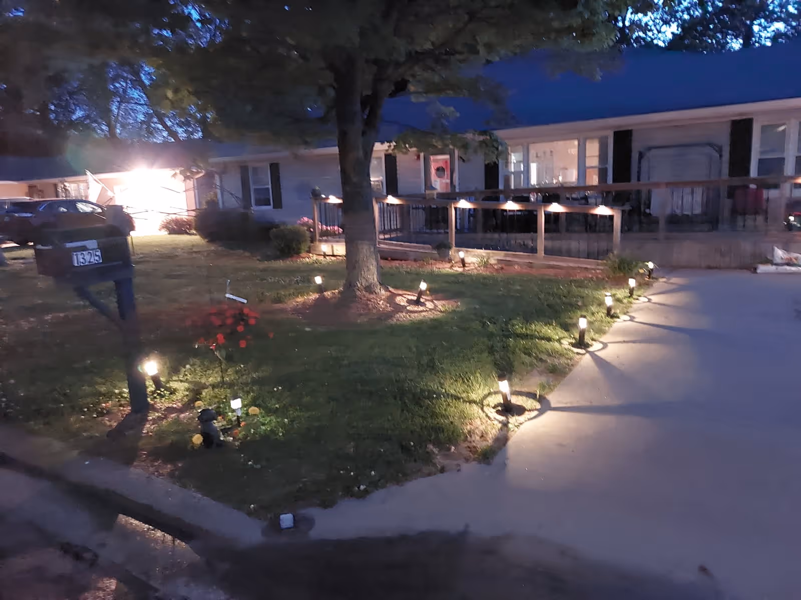 Evening exterior view of Highland Home for Senior's Residential Care, showing lit walkway, ramp, and lawn.