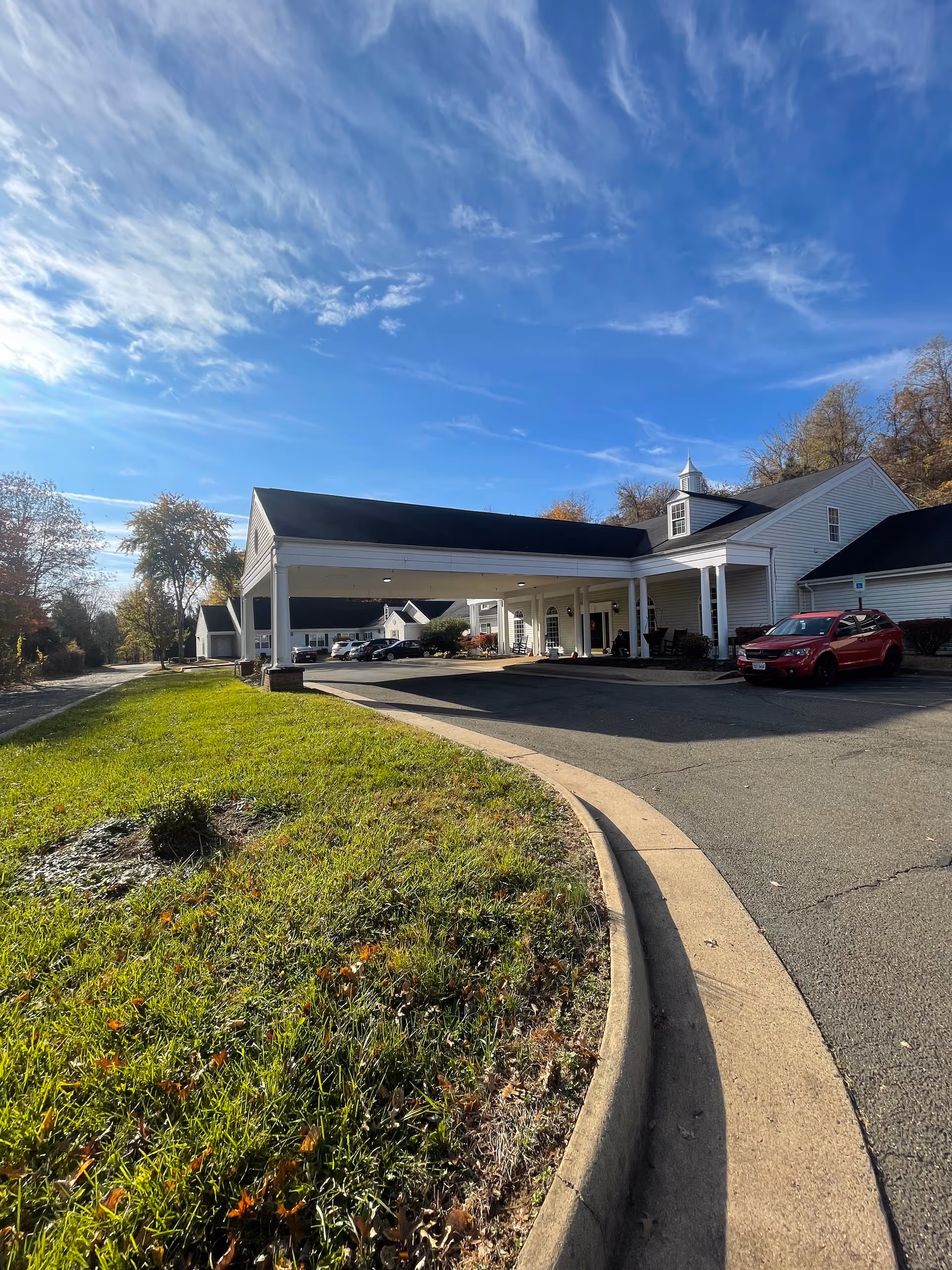 Front view of Spring Oak at Warrenton with covered entrance and parked cars.