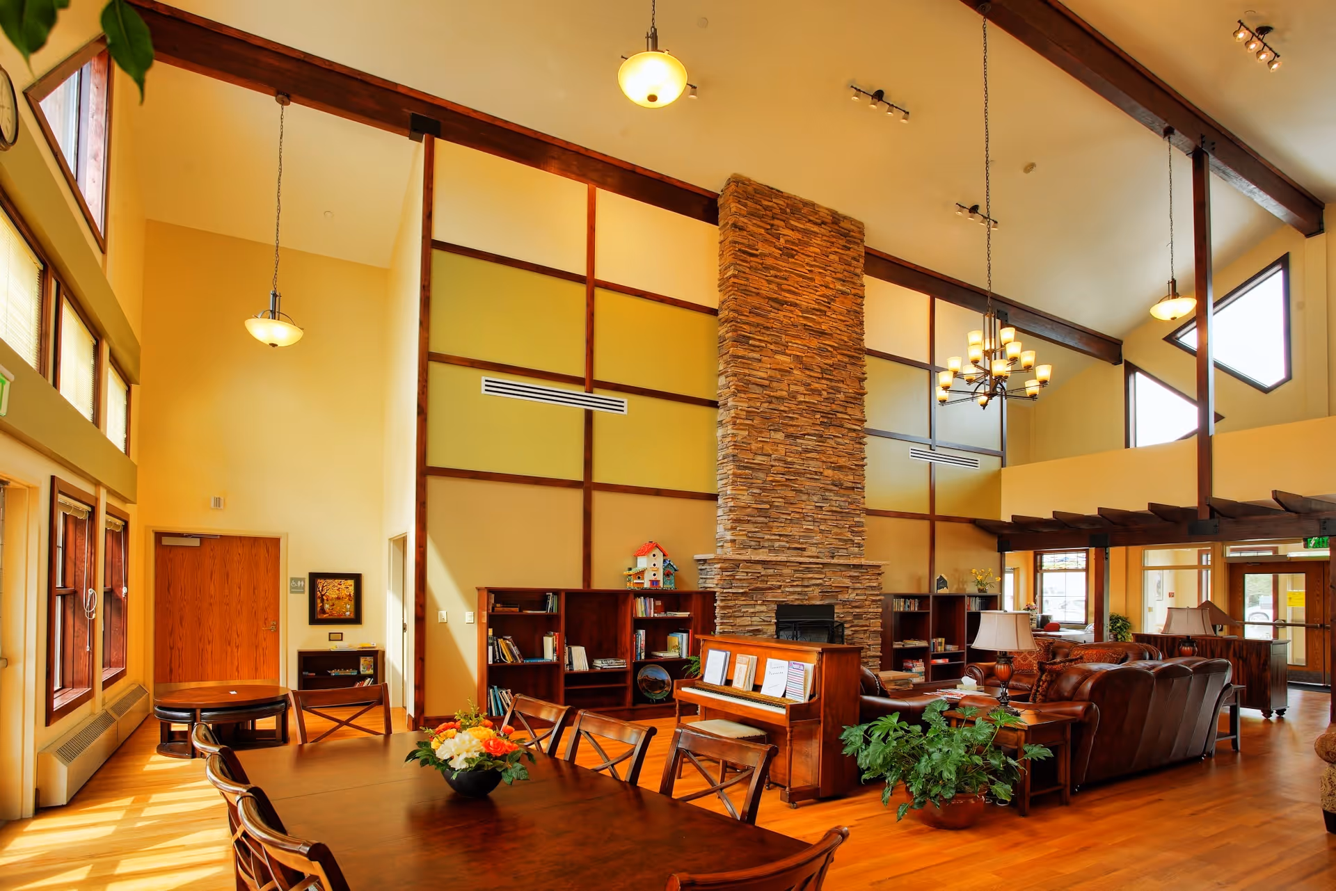 Spacious indoor lodge-style lobby with stone fireplace, high beams, and wooden furnishings.