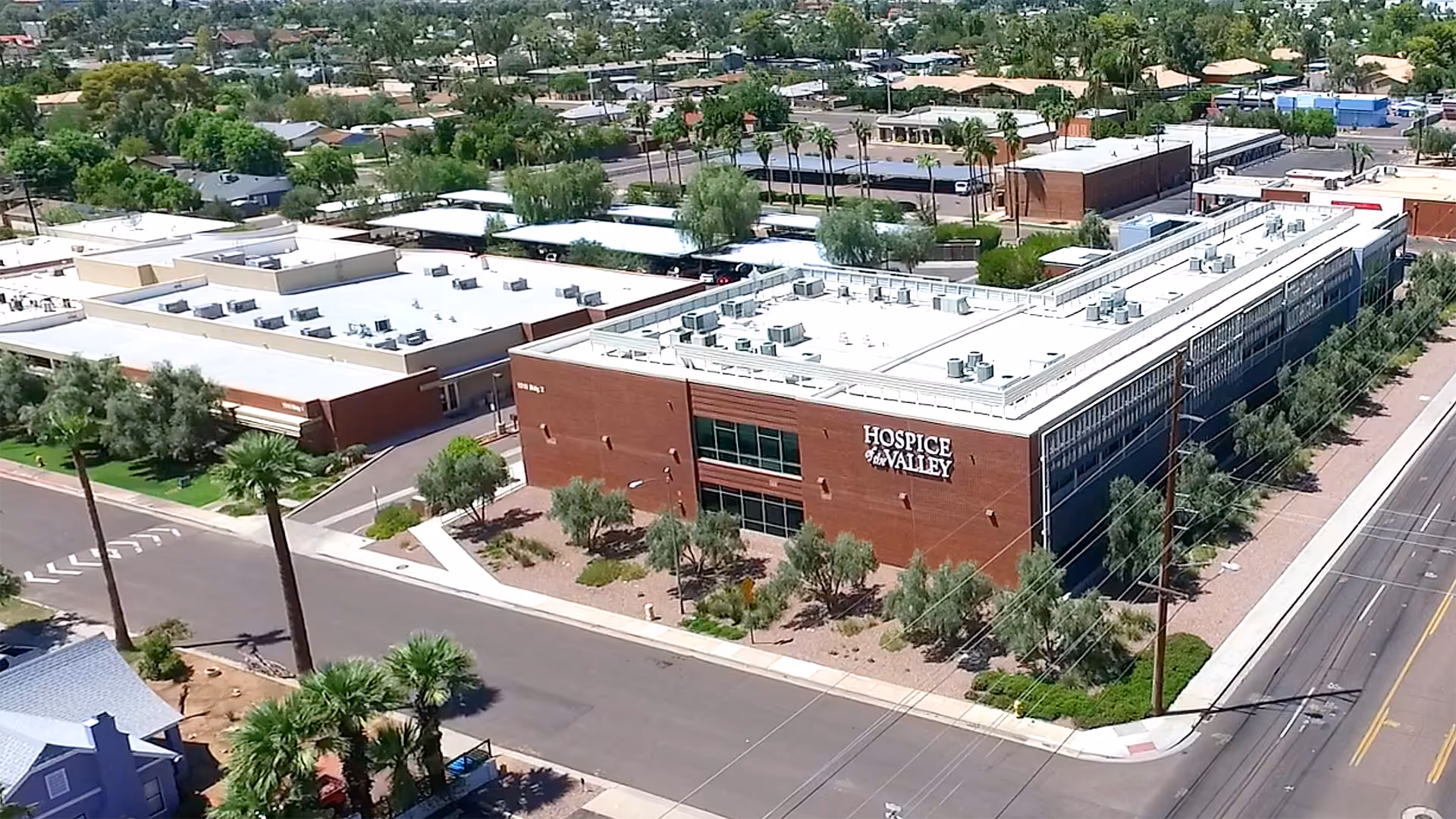 Aerial view of a brick senior care building with Hospice Valley sign and surrounding streets.