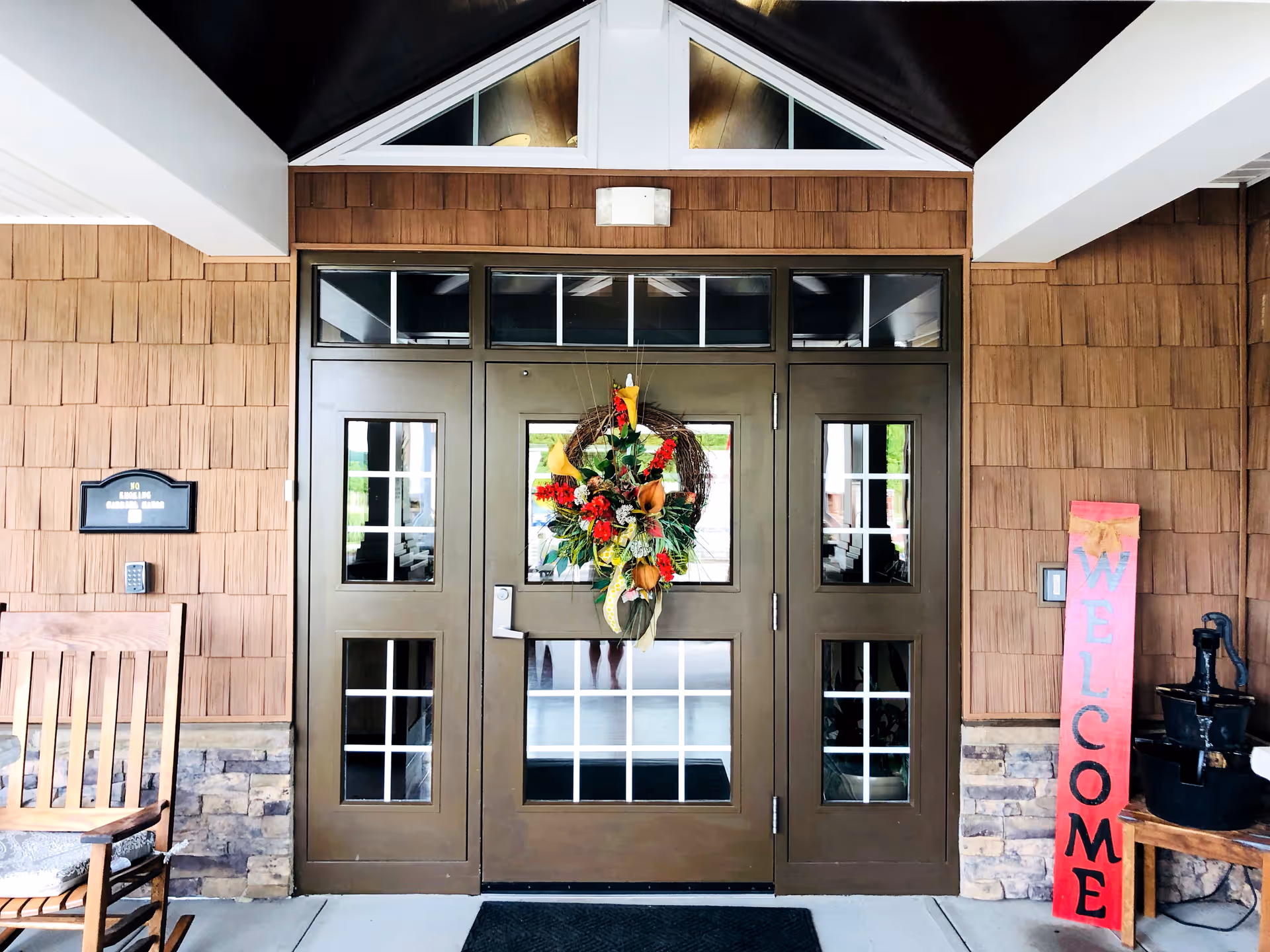 Gabriel Manor exterior entrance with double doors, wreath, and welcome sign.
