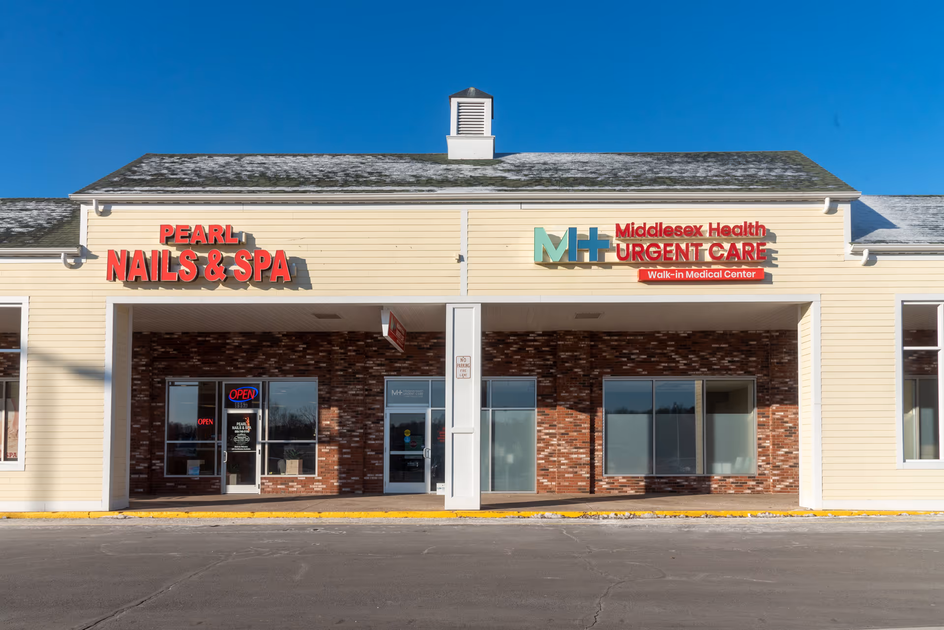 Strip mall storefront showing Pearl Nails and Spa and Middlesex Health Urgent Care signage