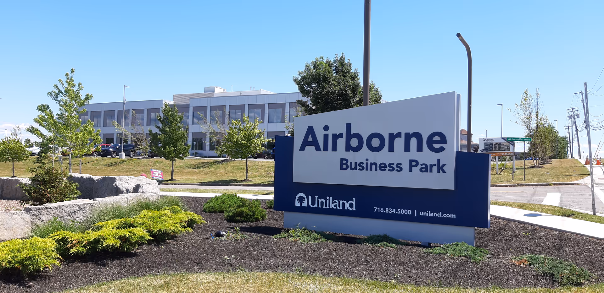 Exterior view of Airborne Business Park sign with landscaping and a modern office building