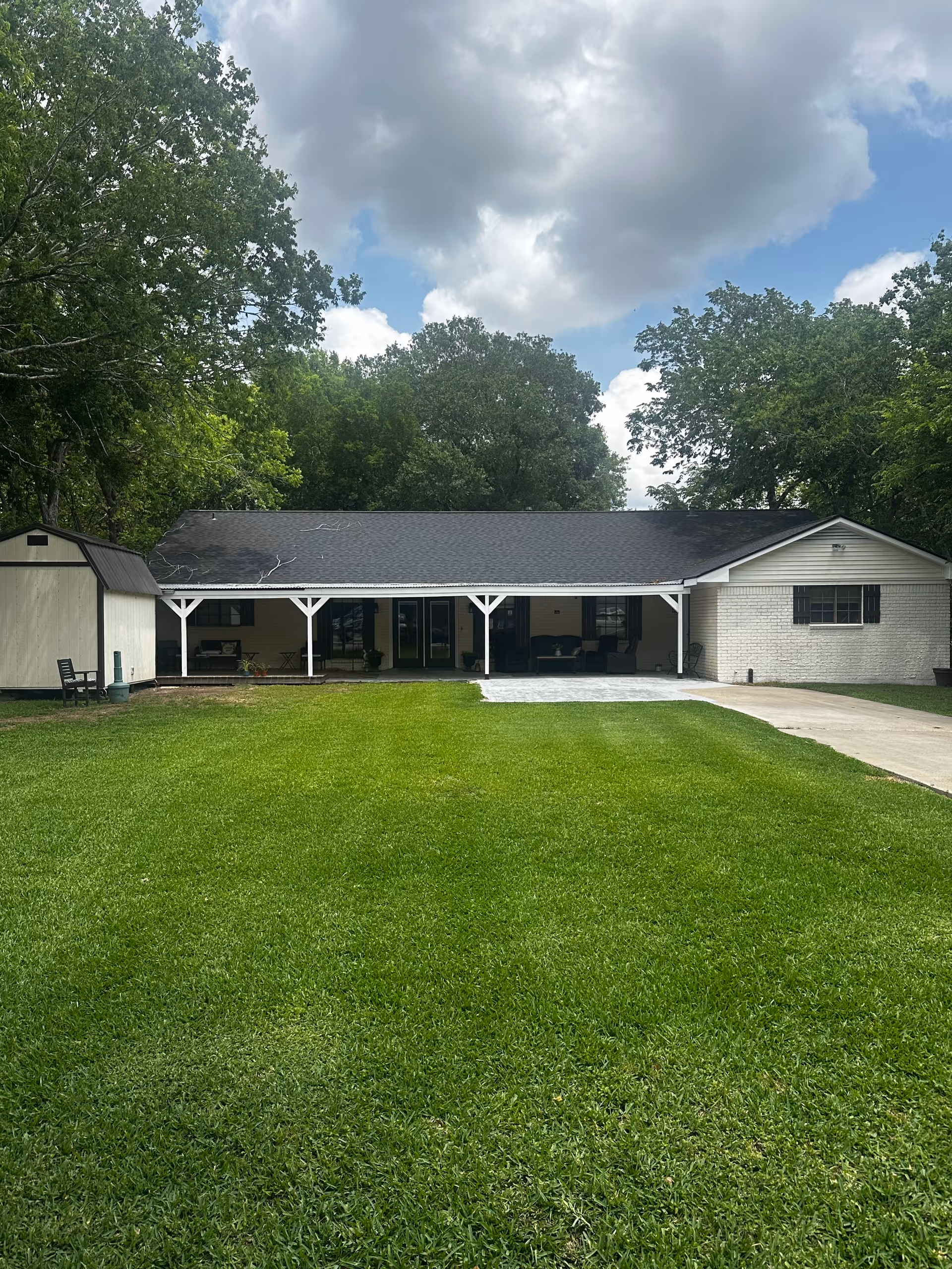 Front view of a single-story building with a covered porch and large grassy lawn.