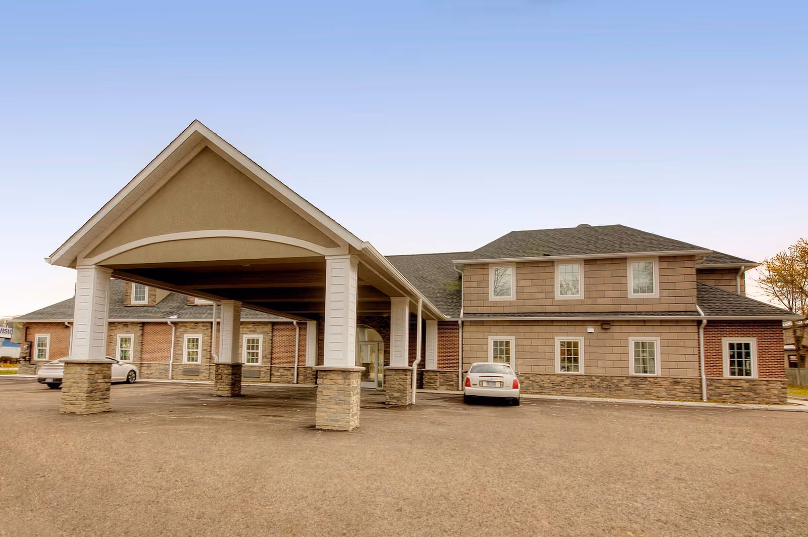 Exterior view of Meadows Assisted Living I with a covered entrance and parked cars.