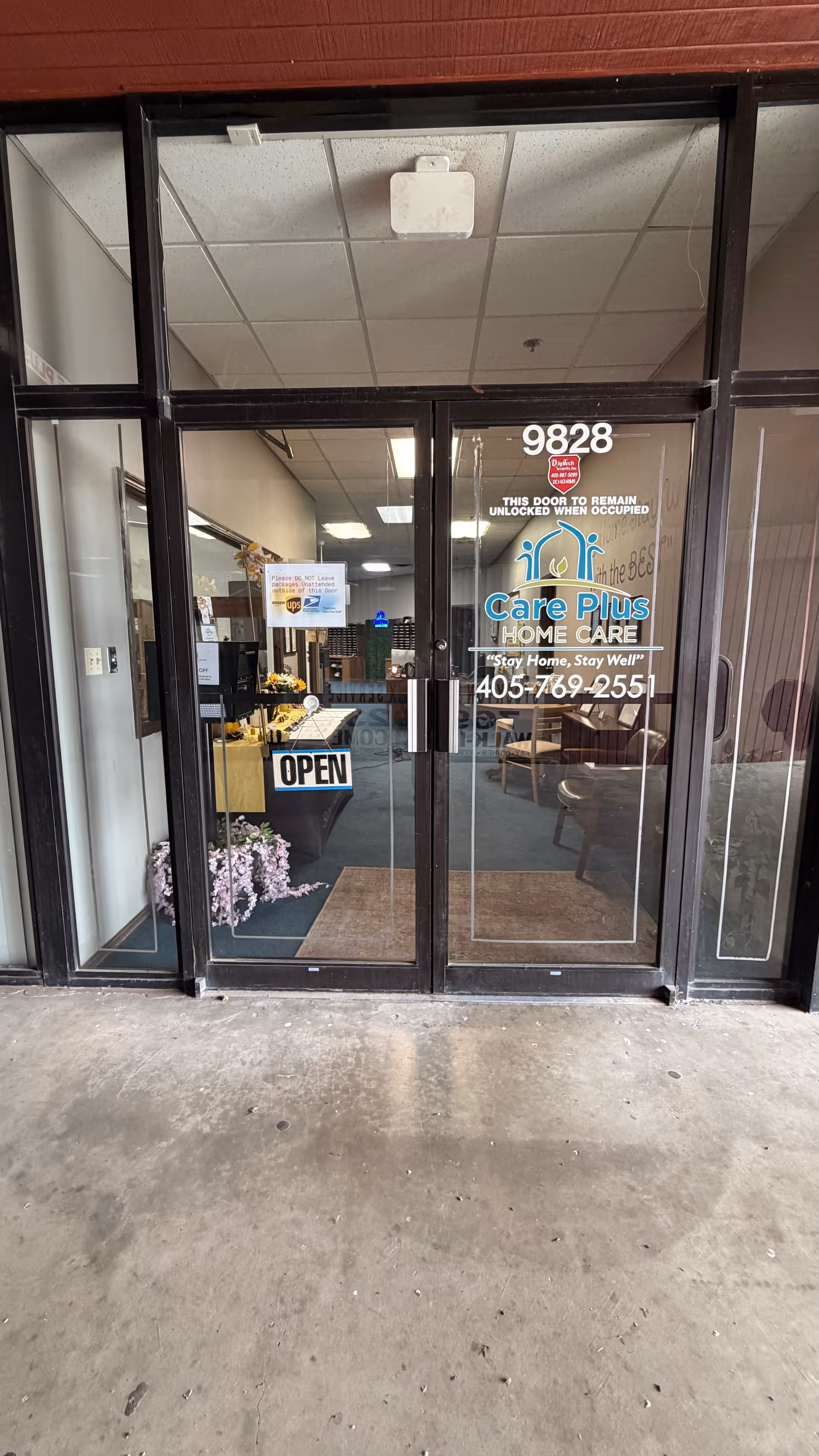 Glass entrance door of Care Plus Home Care with open sign and lobby visible.