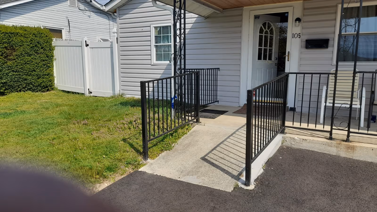 Front entrance of a senior living facility with a ramp, railing, and walkway.