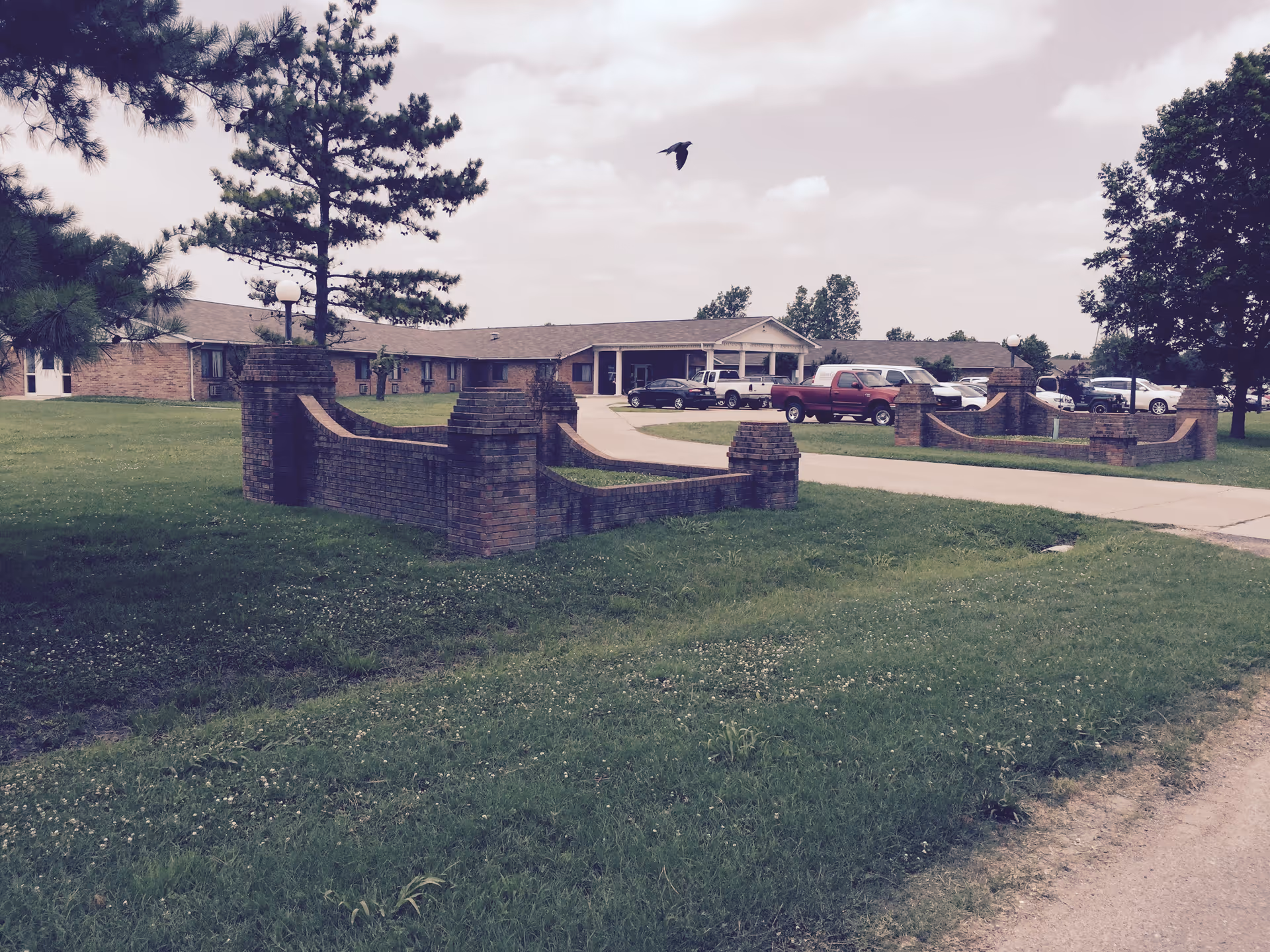 Exterior view of Gideon Care Center with brick entrance walls and parked cars