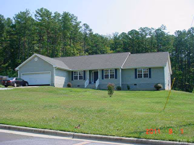 Exterior view of Autumn's Way Care Home: a single-story house with a driveway and green lawn.