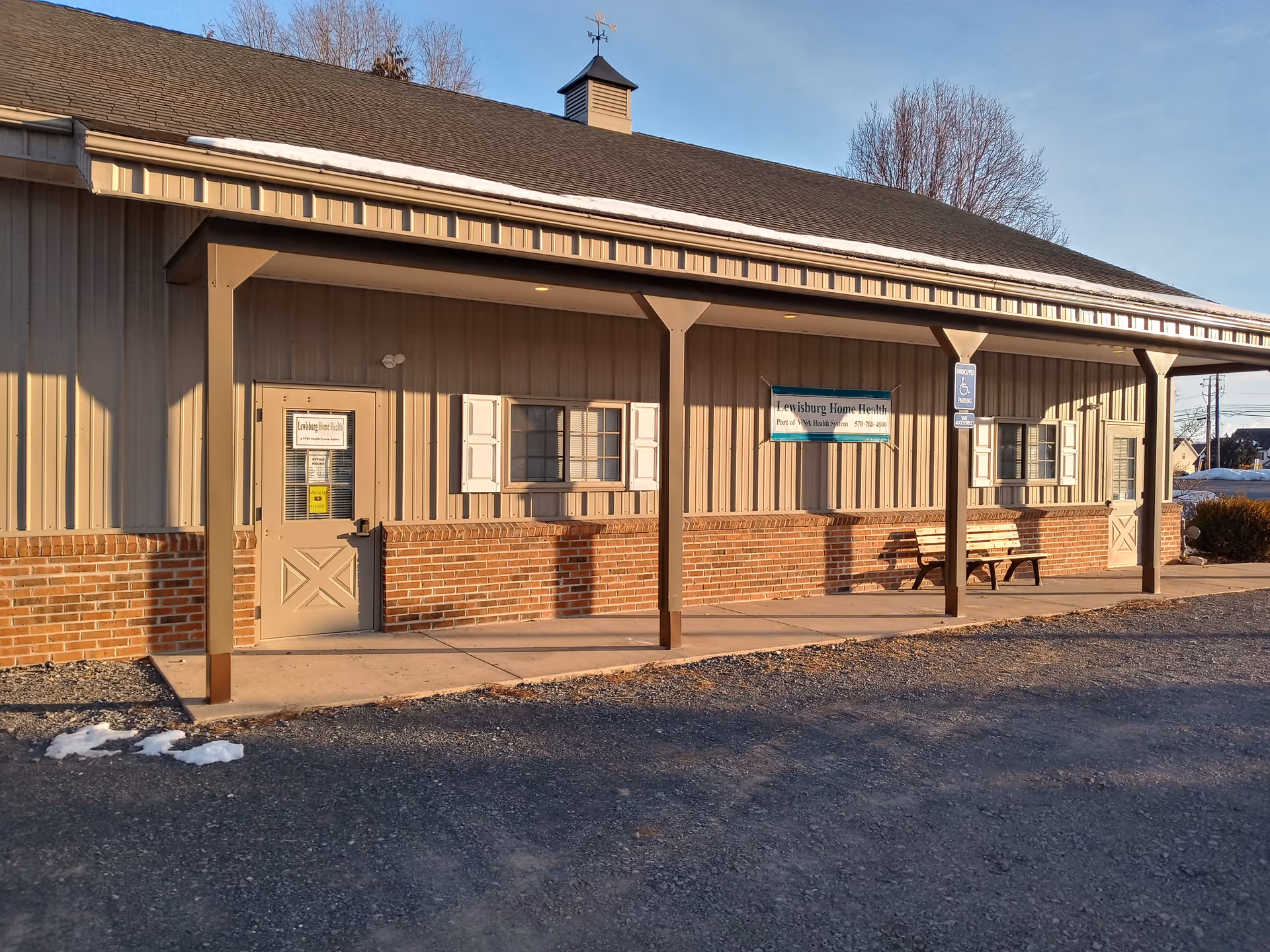 Exterior view of Lewisburg Home Health building with a covered porch and bench