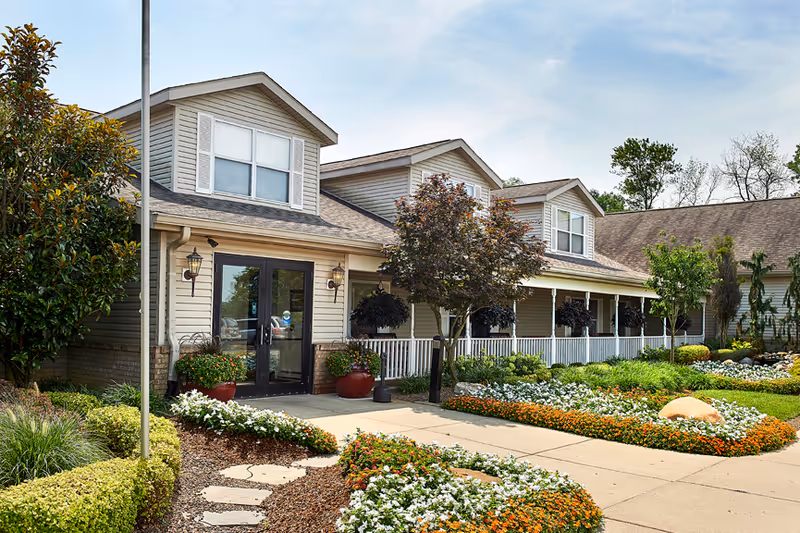 Exterior view of Morristown Manor's front entrance with landscaped walkway and shrubs.