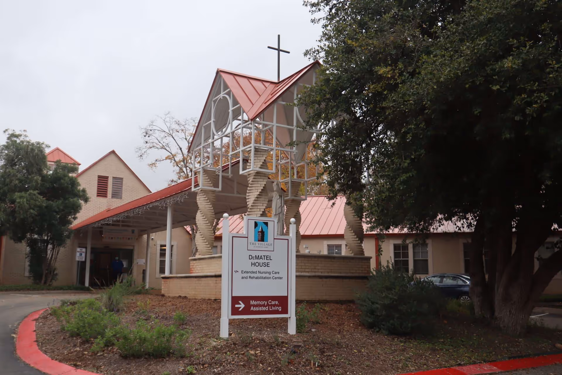 Front exterior of The Village at Incarnate Word with a chapel-like entrance and sign.