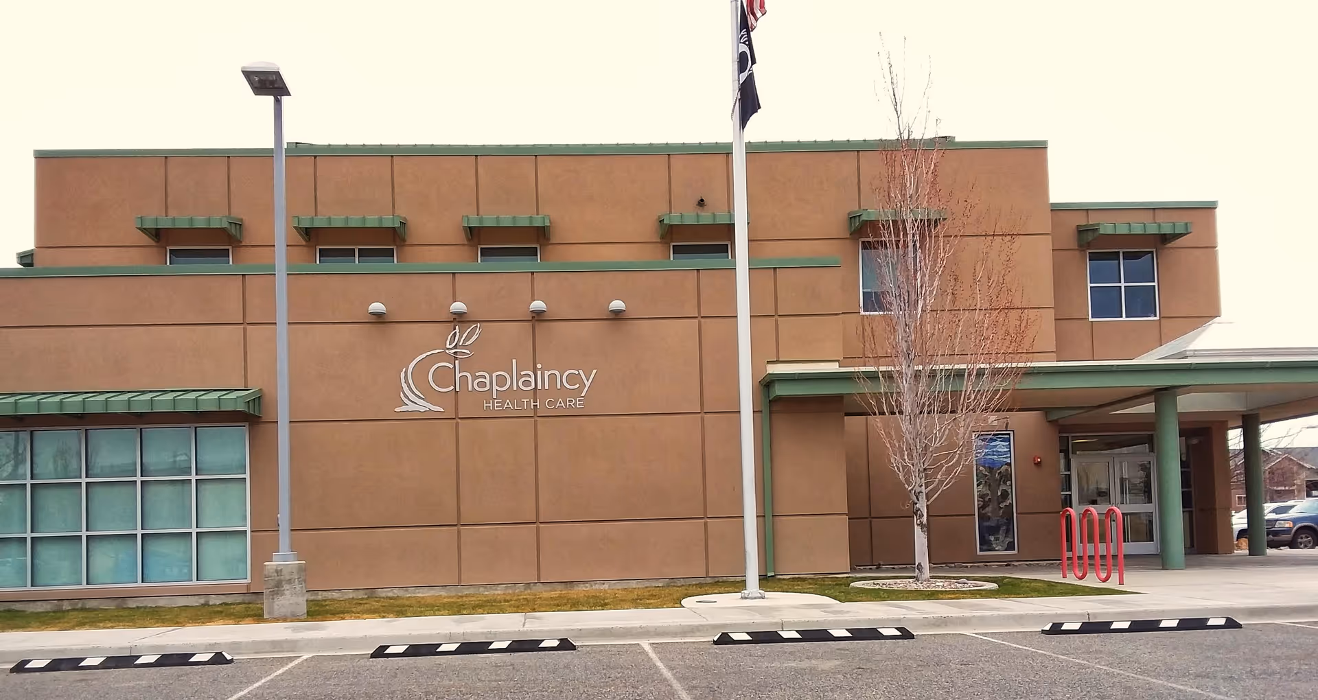 Exterior view of a brown medical facility with Chaplaincy Health Care signage and entrance.
