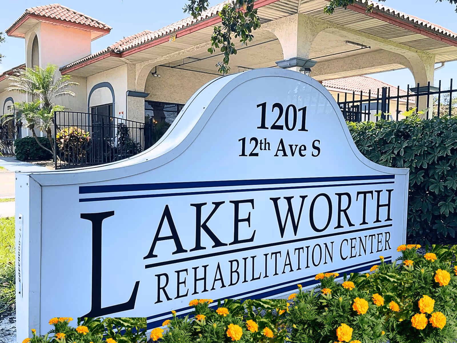 Large white sign reading Lake Worth Rehabilitation Center in front of a building