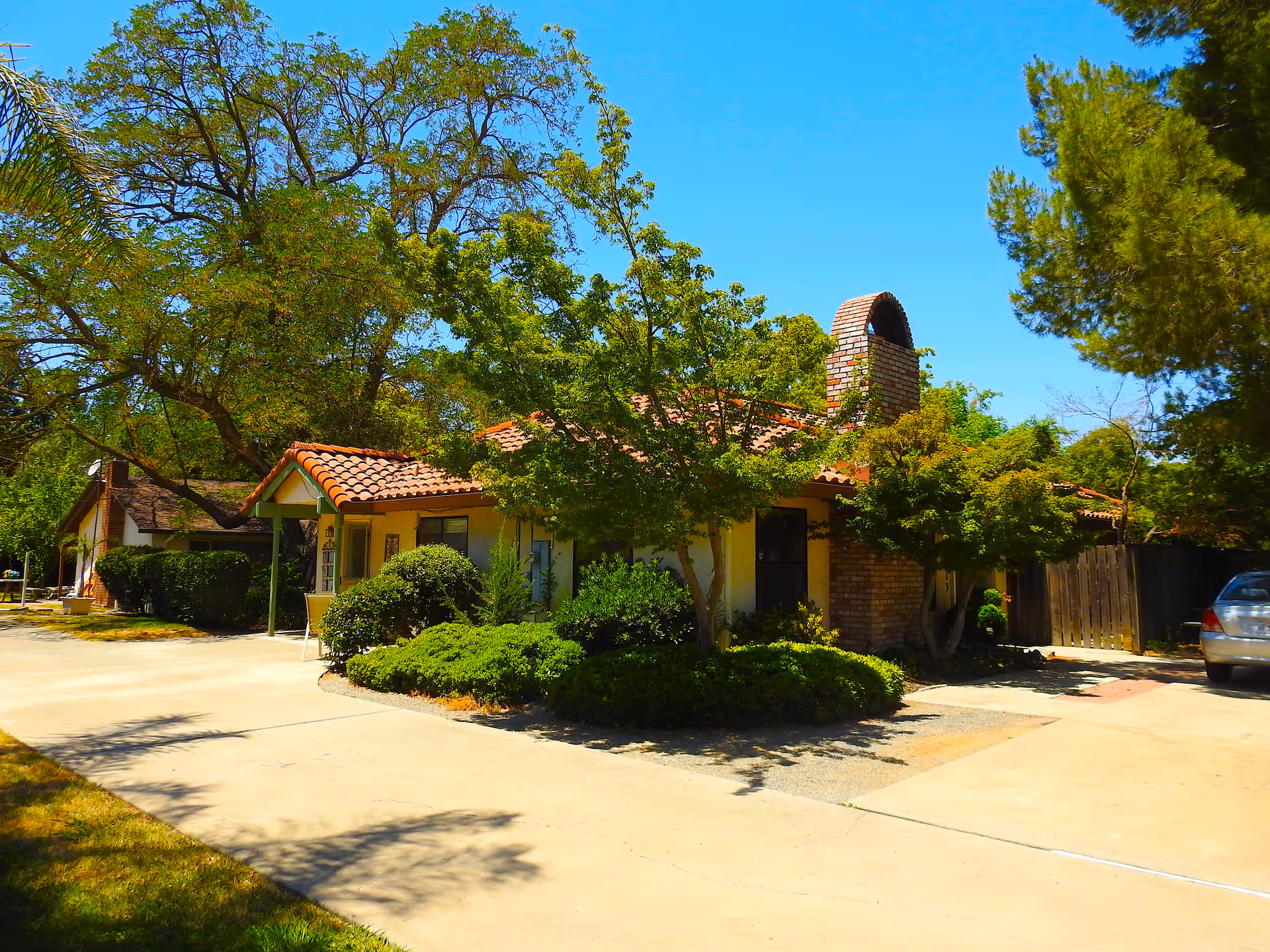 Single-story elder care facility with tiled roof and lush front yard.