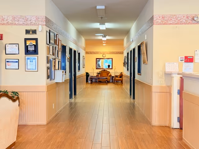 Long, well-lit hallway at Foremost Senior Campus with framed notices and seating at the end.